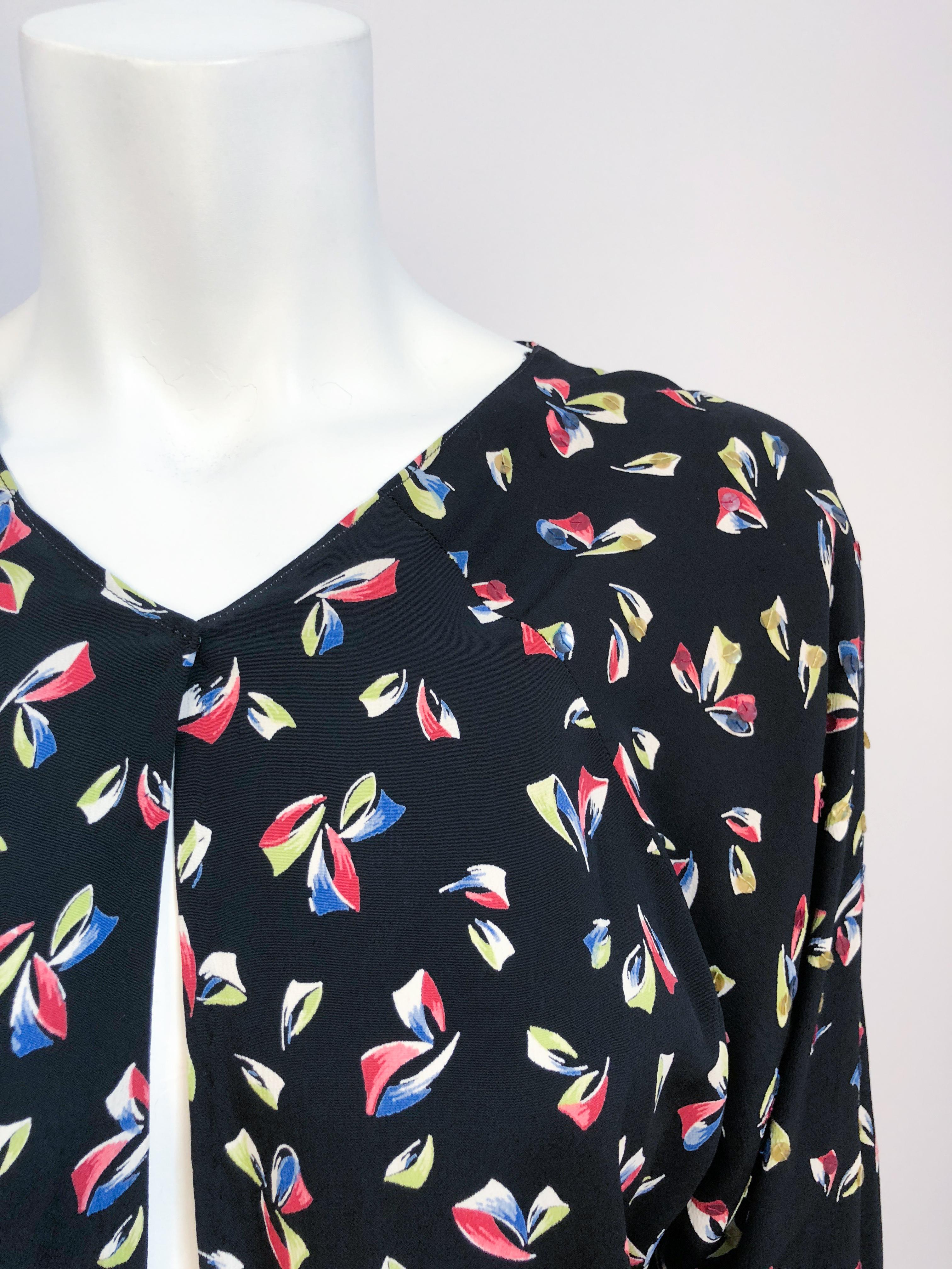 1930s Fantasy Printed top. Black Rayon top with green, red, and blue fantasy print and sequin along the shoulders. A single snap closure at the bottom of the neckline.