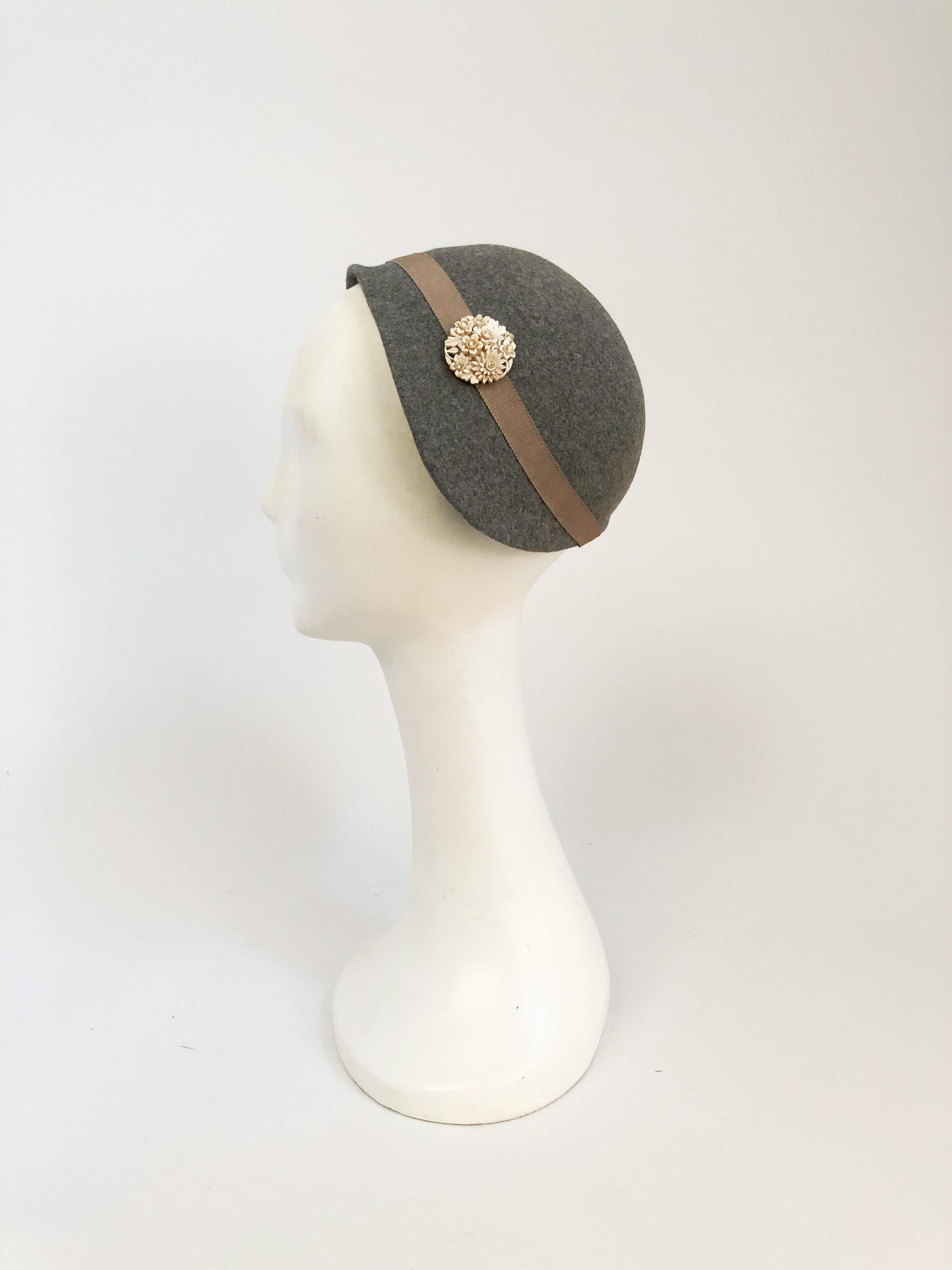1930s Grey Cashmere Wool Hat with White Carved Button. Grey cashmere wool felt hat with gros-grain taupe hat band and floral carved button with rhinestones.