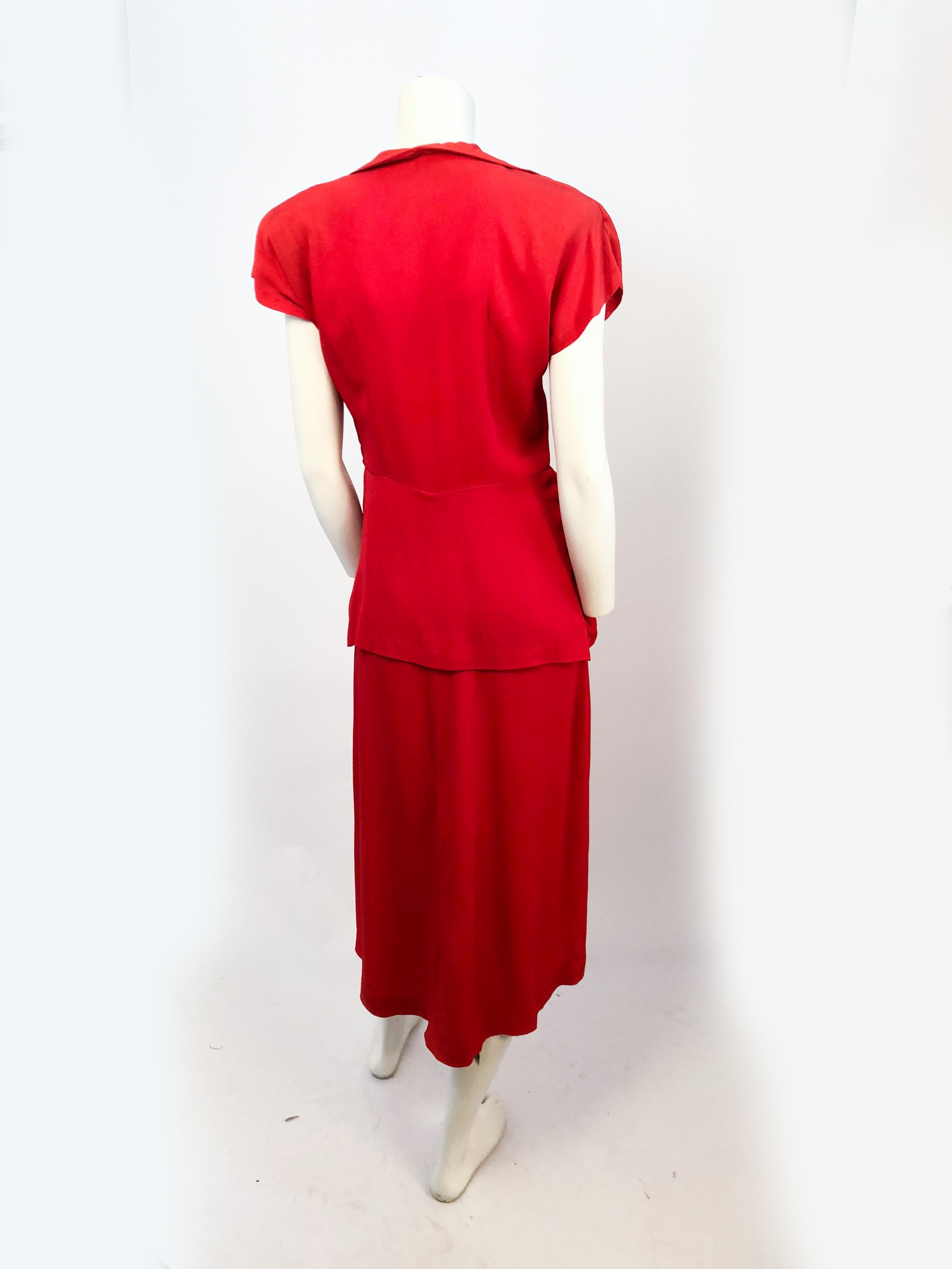 1940s Red Crepe Dress with Stud and Rhinestone Accents. Also features padded shoulders, full peplum, and covered buttons.