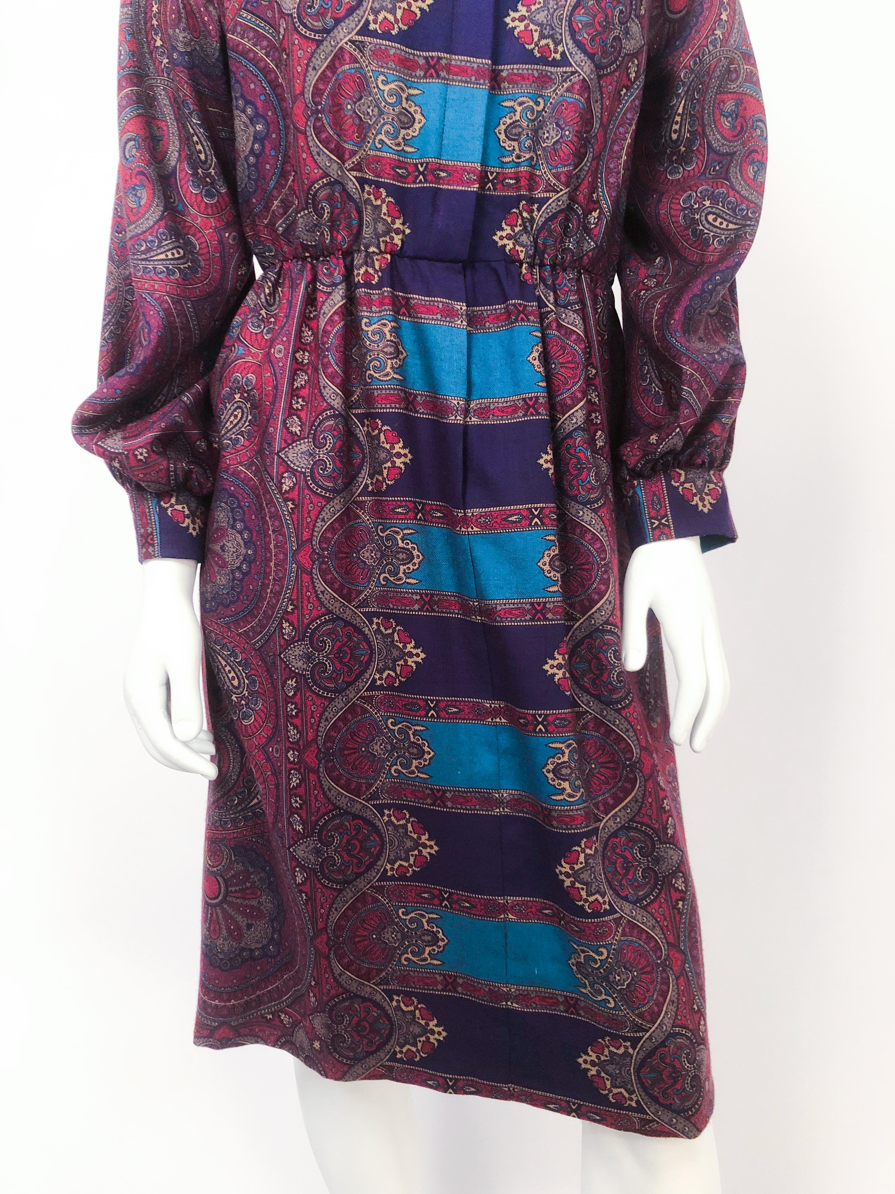 1960s Helga Howie Jewel Toned Paisley Dress with cuffed/gathered sleeves, elastic waist, nehru collar, lined in silk, and buttoned front closure. Made of wool challis. 