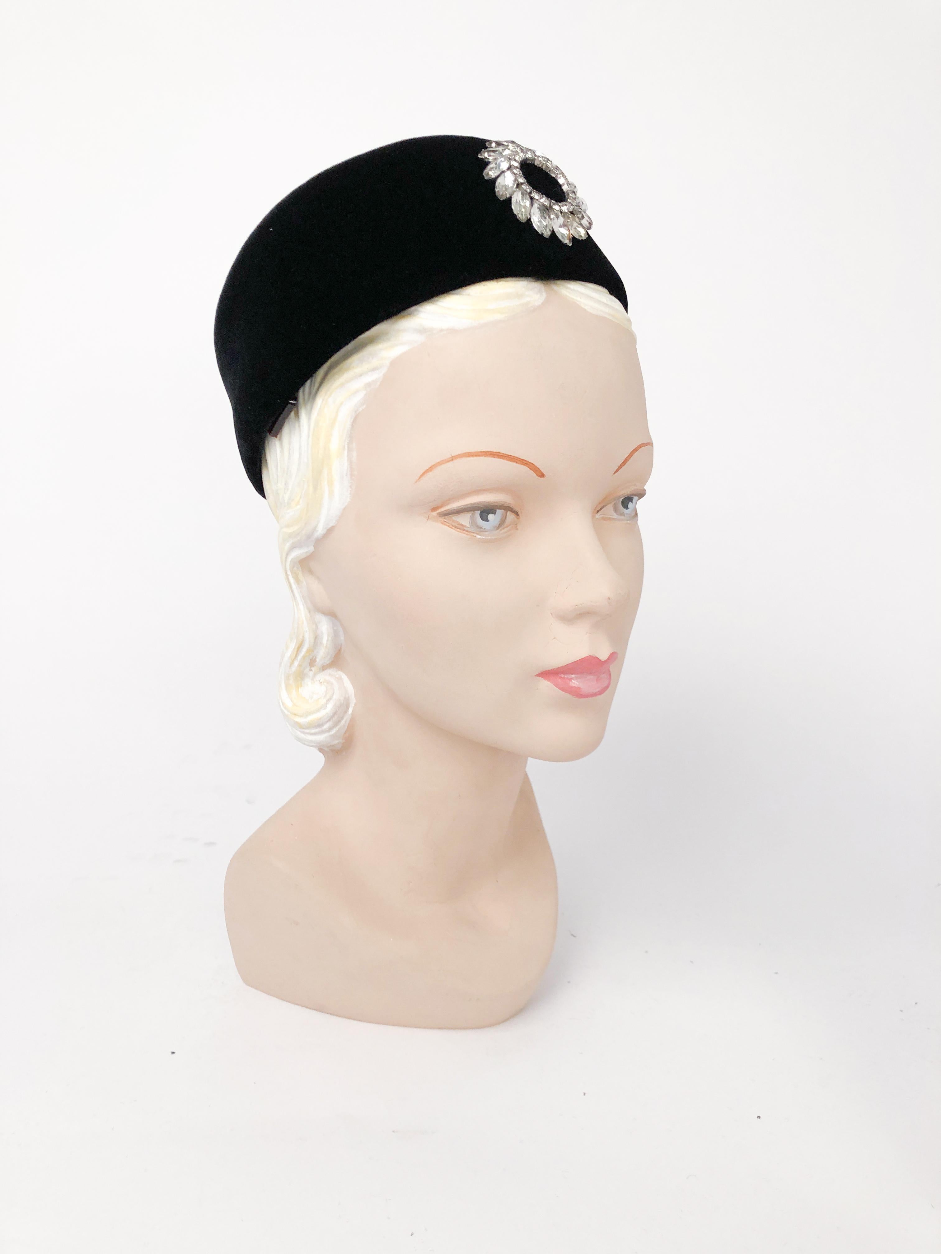 1960s Black Velvet Pillbox Hat with Rhinestone wreath shaped accent. The inside of the hat has hair combs to further secure the hat to the head.