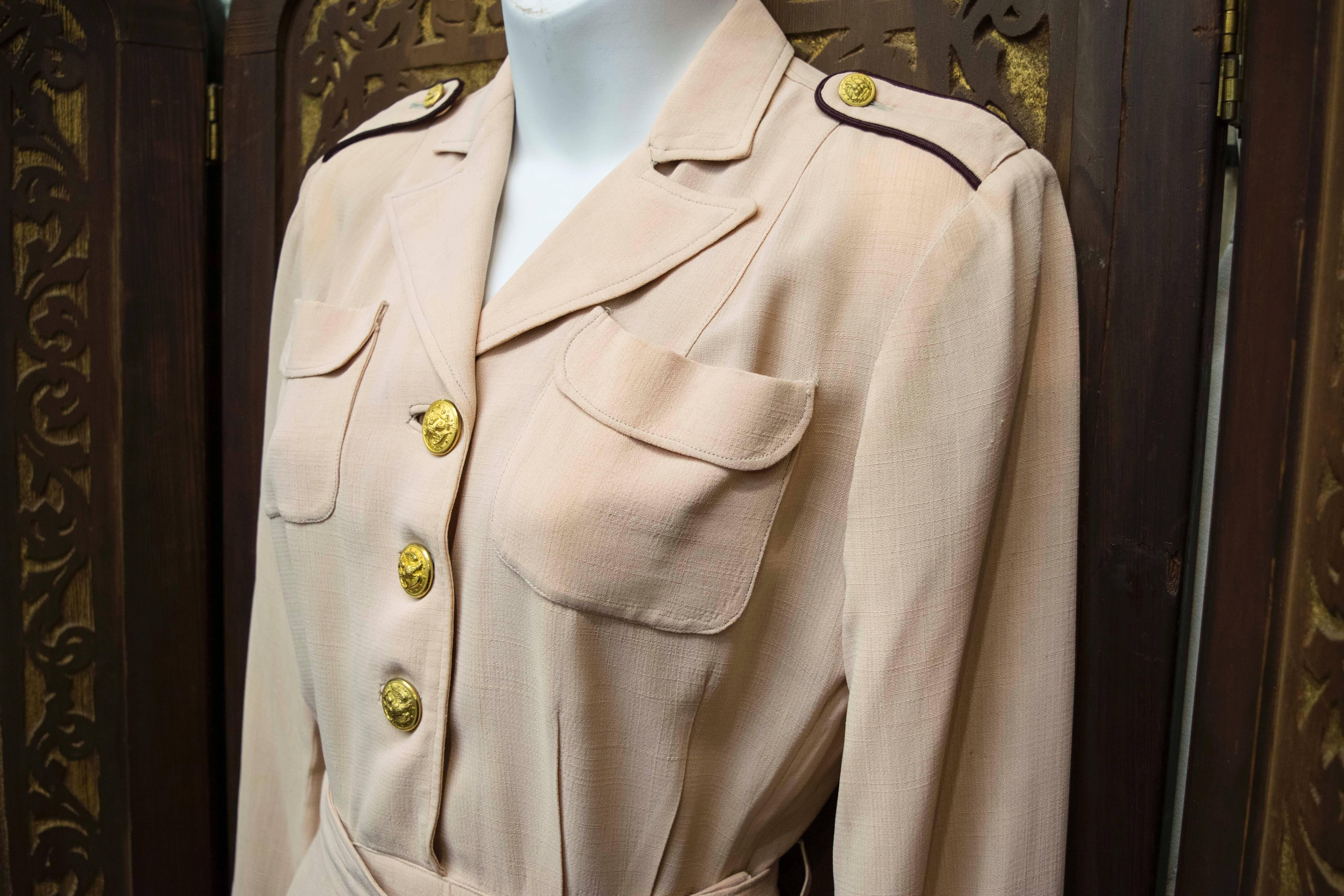 1940s US Nurses Outfit.
This stunningly chic US nurses outfit is beautifully preserved with original belt, cufflinks, epaulets, buttons and metal zipper. Made in a rose beige crepe, this piece is very reminiscent of Chanel. 
The original hem has