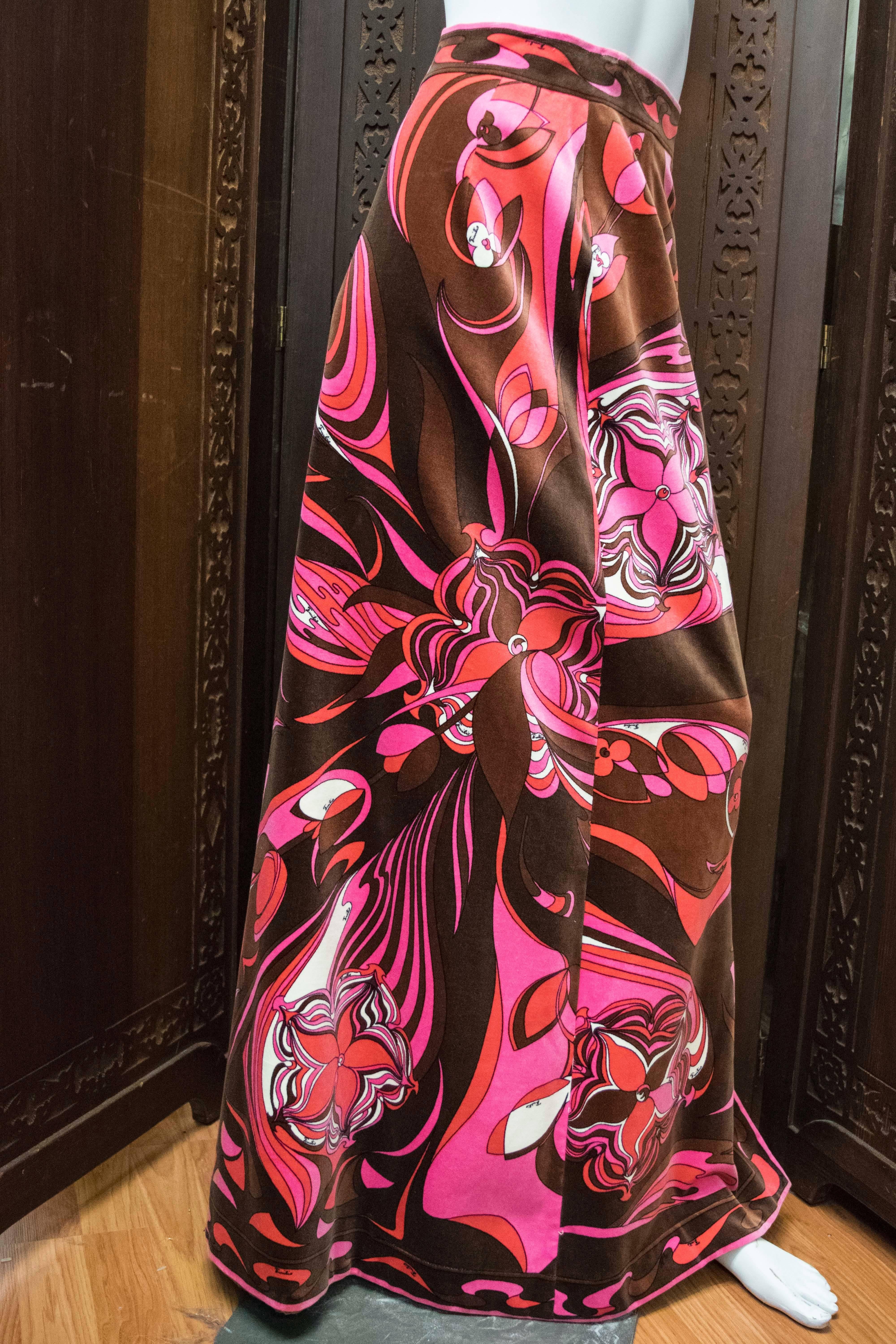 A-line flared velvet maxi skirt by Emilio Pucci. The kaliadscopic graphic print has panels of vibrantly colored florals in pinks, browns and burgundy. Side zip entry. Originally retailed by Saks Fifth Ave.