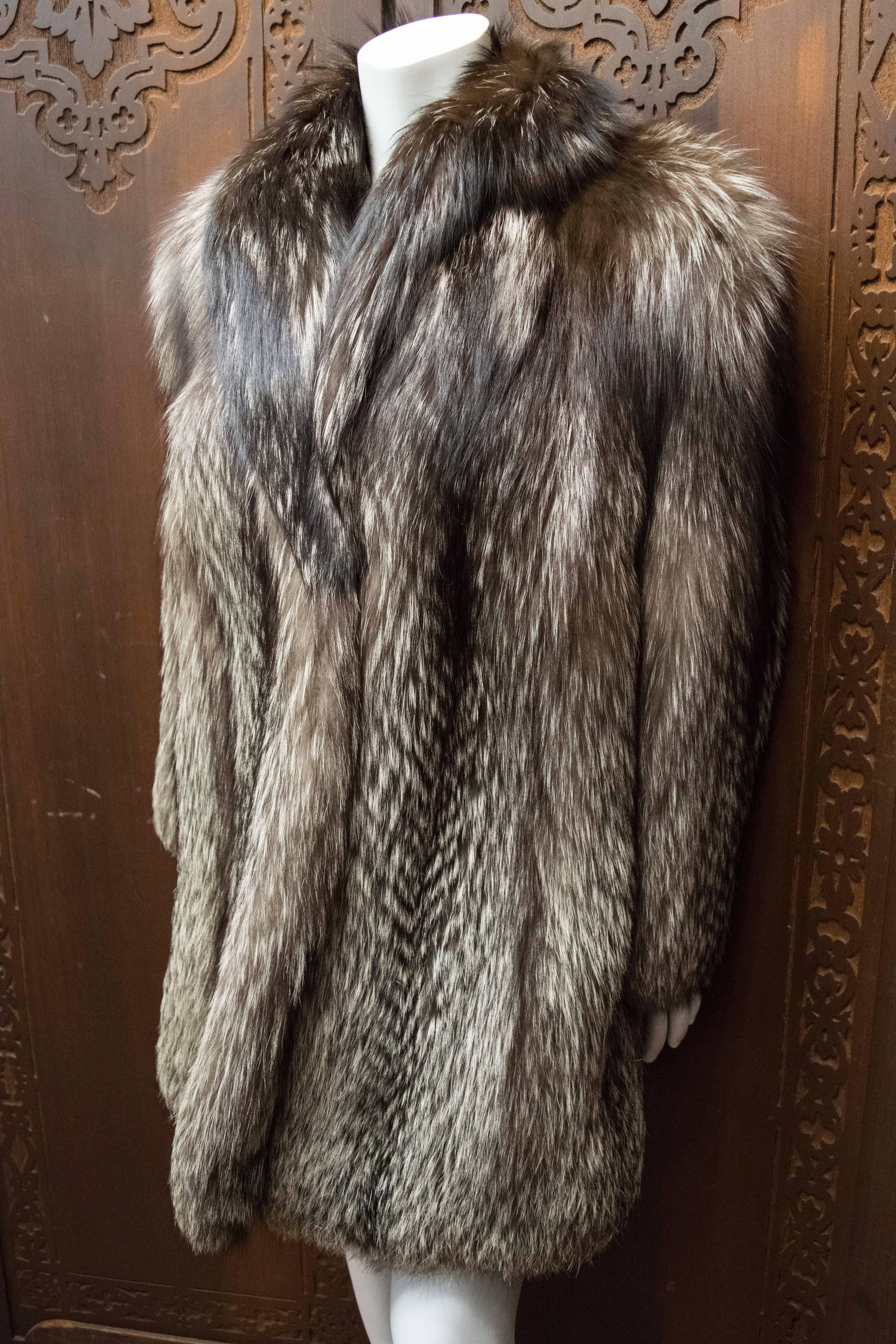 1940s Silver Fox Fur Coat.

Luxurious silver fox coat of high quality skins with beautiful natural coloration. The straight, slim body has vertical skins and wonderful, thick shawl collar. The coat drapes very nicely on the body. 

B 42
W 40
H