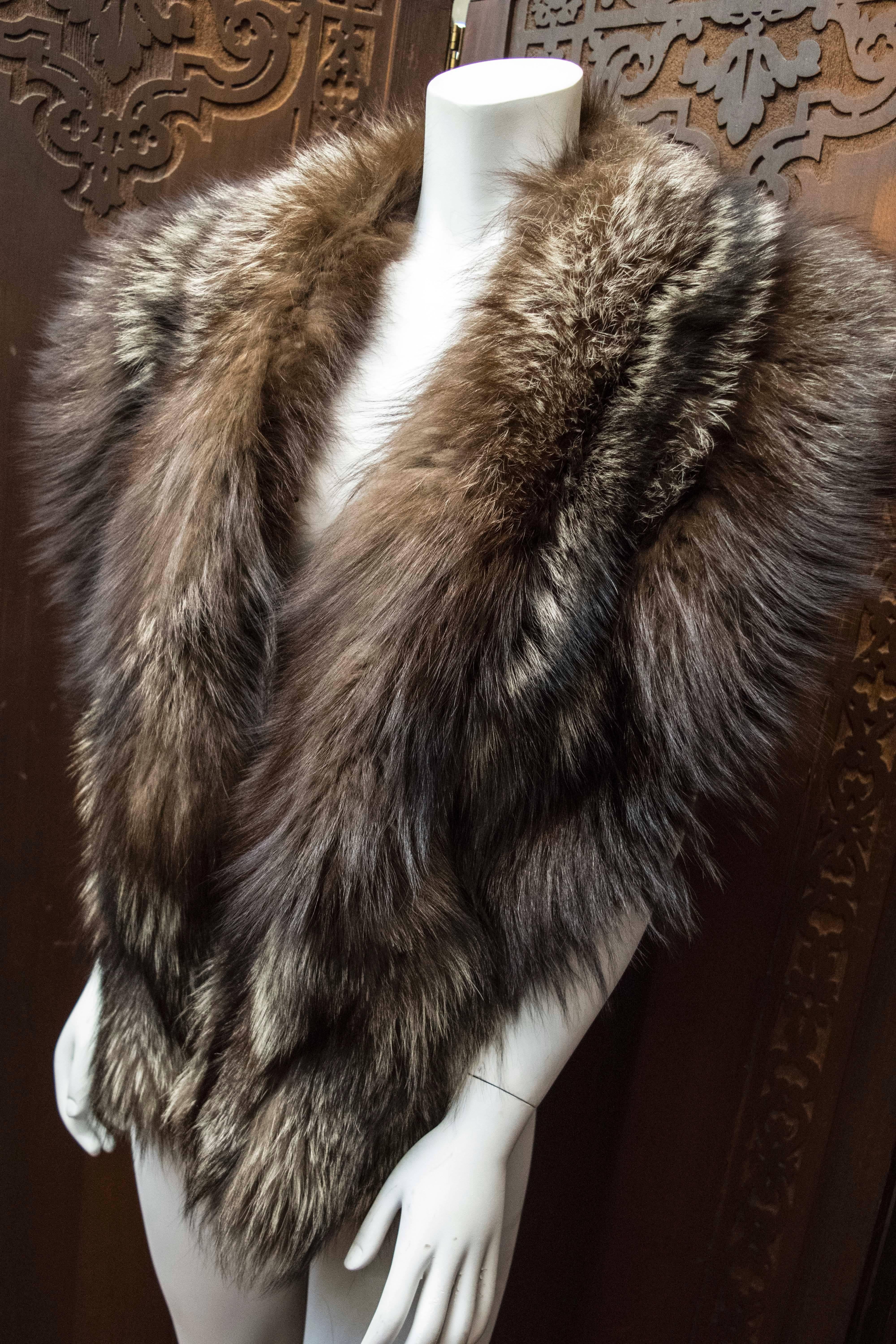 Silver Fox Fur Wrap

This luxurious silver Fox fur wrap is soft, long, and fluffy with a stunning lamé lining. The fur has retained it’s supple skin and the underfur, guard hairs remain soft, dense, and fluffy. The piece has fur clasps in the