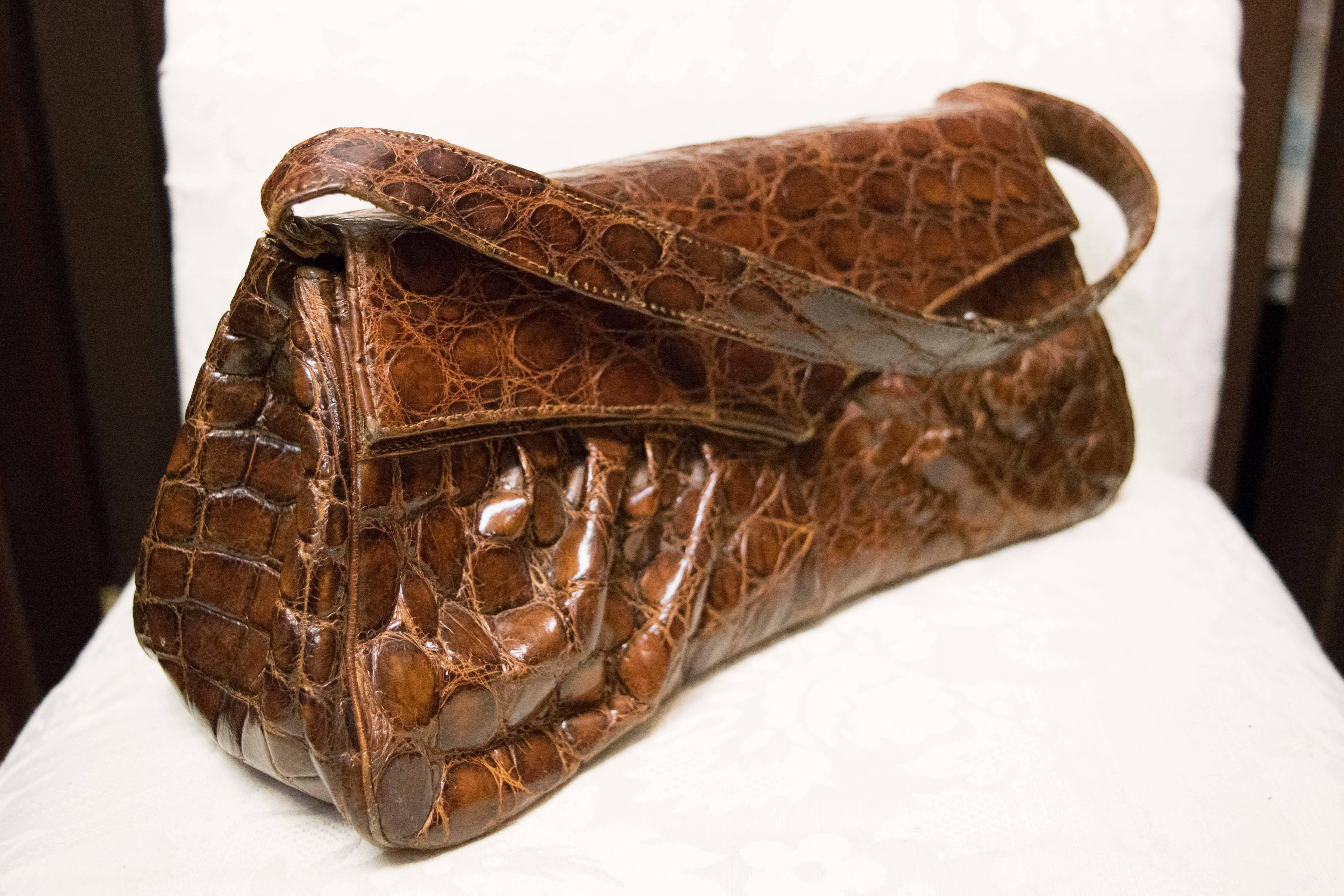 1940s Rouched Alligator Handbag   

Beautiful gathered alligator handbag circa 1940, with snap closure and three interior pockets.

L 11.5
H 5
D 5