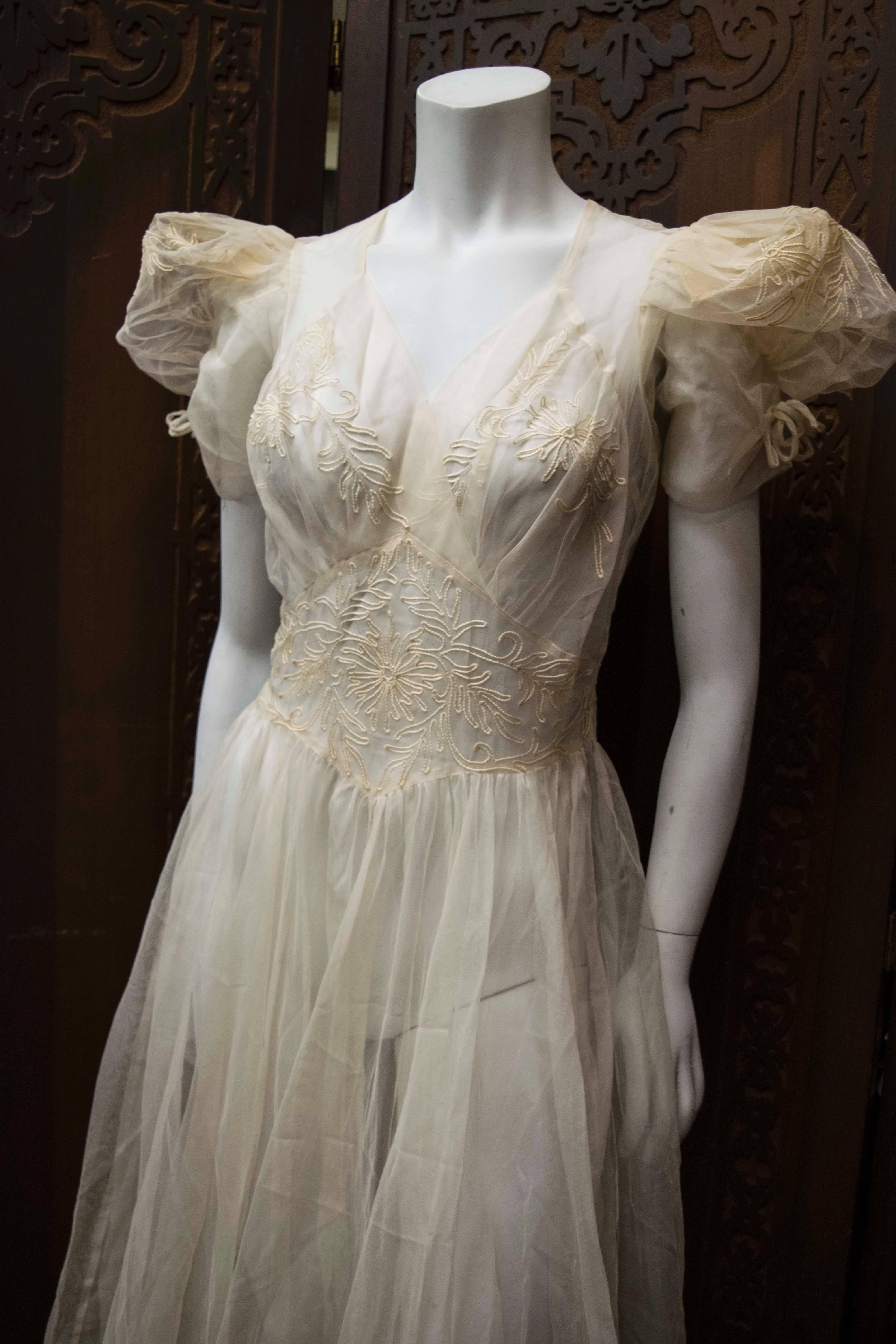 1930s Sheer Ivory Wedding Dress

Absolutely stunning 1930s sheer ivory wedding dress with soutache bodice and horse hair sleeves and hem. 
Comes with slip. 

B 36
W 27
L 60