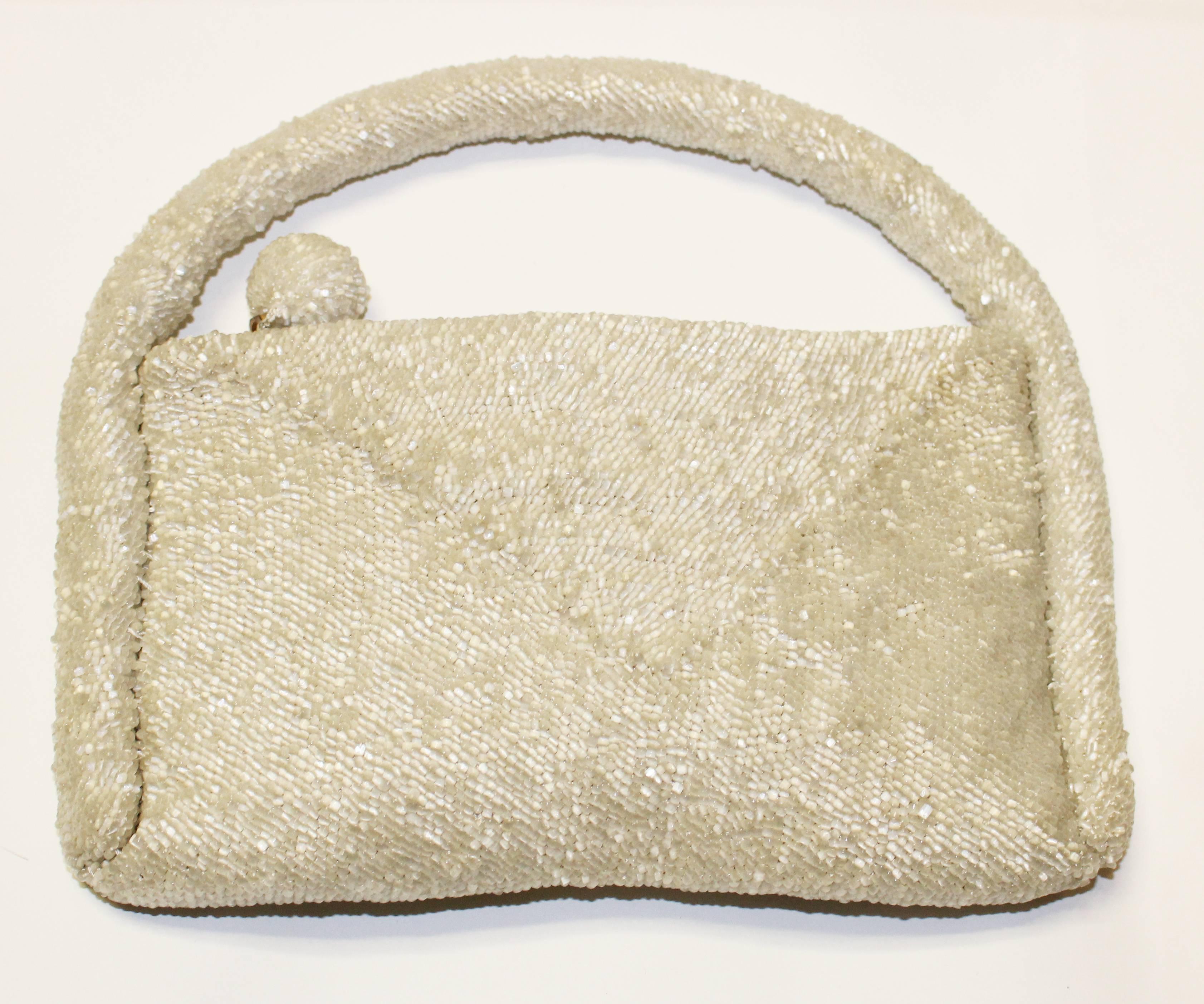 1930's ivory hand-beaded purse with beaded snowball zipper-pull and wrap-around handle. 

Measurements:
Width: 9