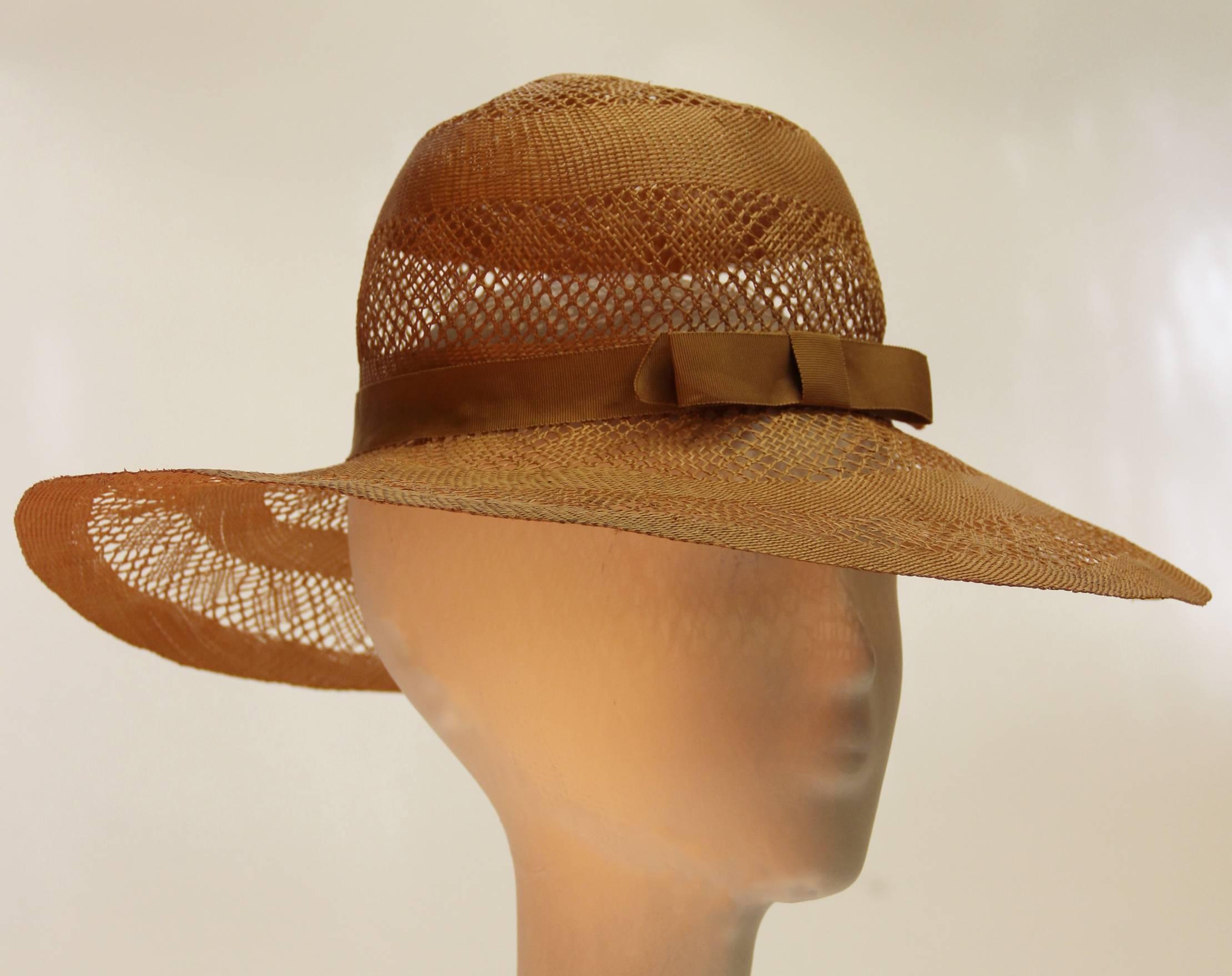 1970's Halston woven straw wide brimmed sun hat. Delicate lace like pattern.Grosgrain ribbon trim with bow. Like new condition. 

Measurement: 21 1/2
