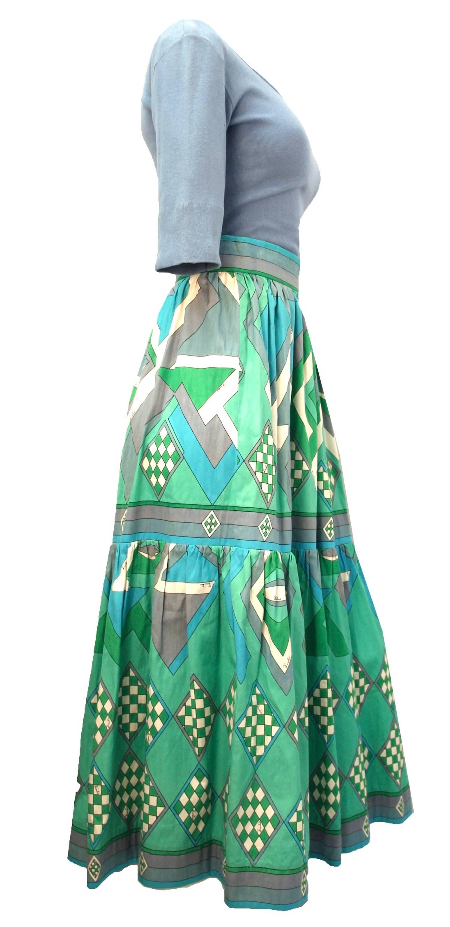 Great summertime 1970s two-piece Emilio Pucci 100% cotton ensemble. Scoop neck t-shit with elbow length roll up sleeves. Tea length cotton Skirt with fitted waistband and two tiers in classic Pucci print. Subtle gathering on second tier gives the
