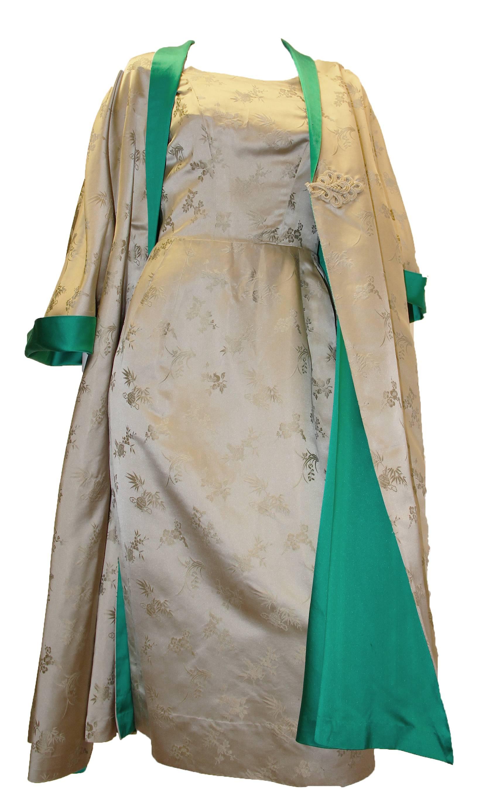 zweiteiliges Chinoiserie-Abendkleid aus Seide aus den 1950er Jahren. Sowohl der Mantel als auch das Kleid haben Vordertaschen! Metallreißverschluss am Kleid. Froschverschluss an der Jacke.  

Abmessungen: 
Kleid (tailliert:: Seidenstoff gibt nicht