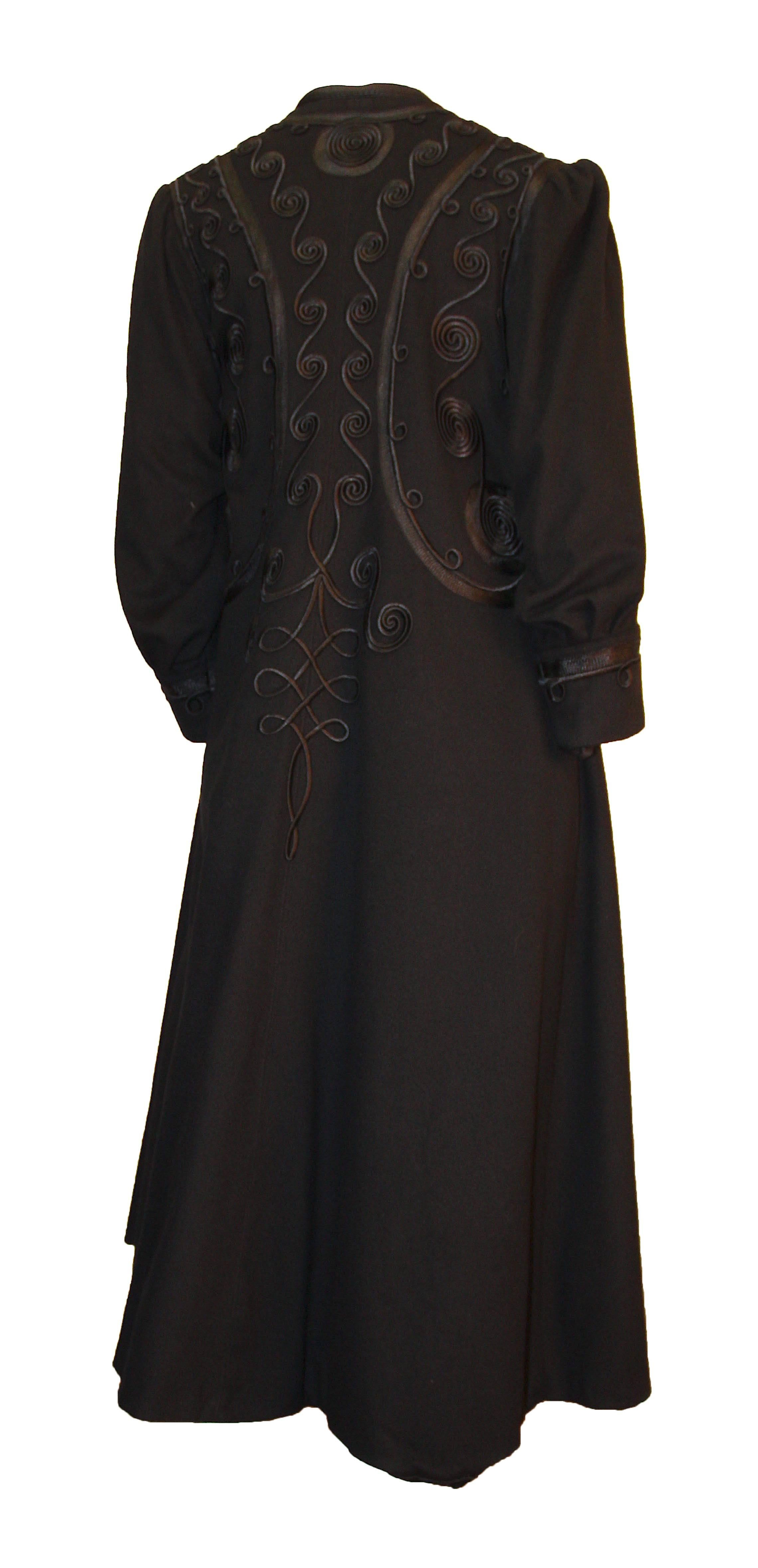 Manteau noir édouardien avec garniture en soie élaborée sur tout le corps et aux poignets. Légèrement froncé à l'épaule. Boutons sur le devant. Entièrement doublé en soie noire.  