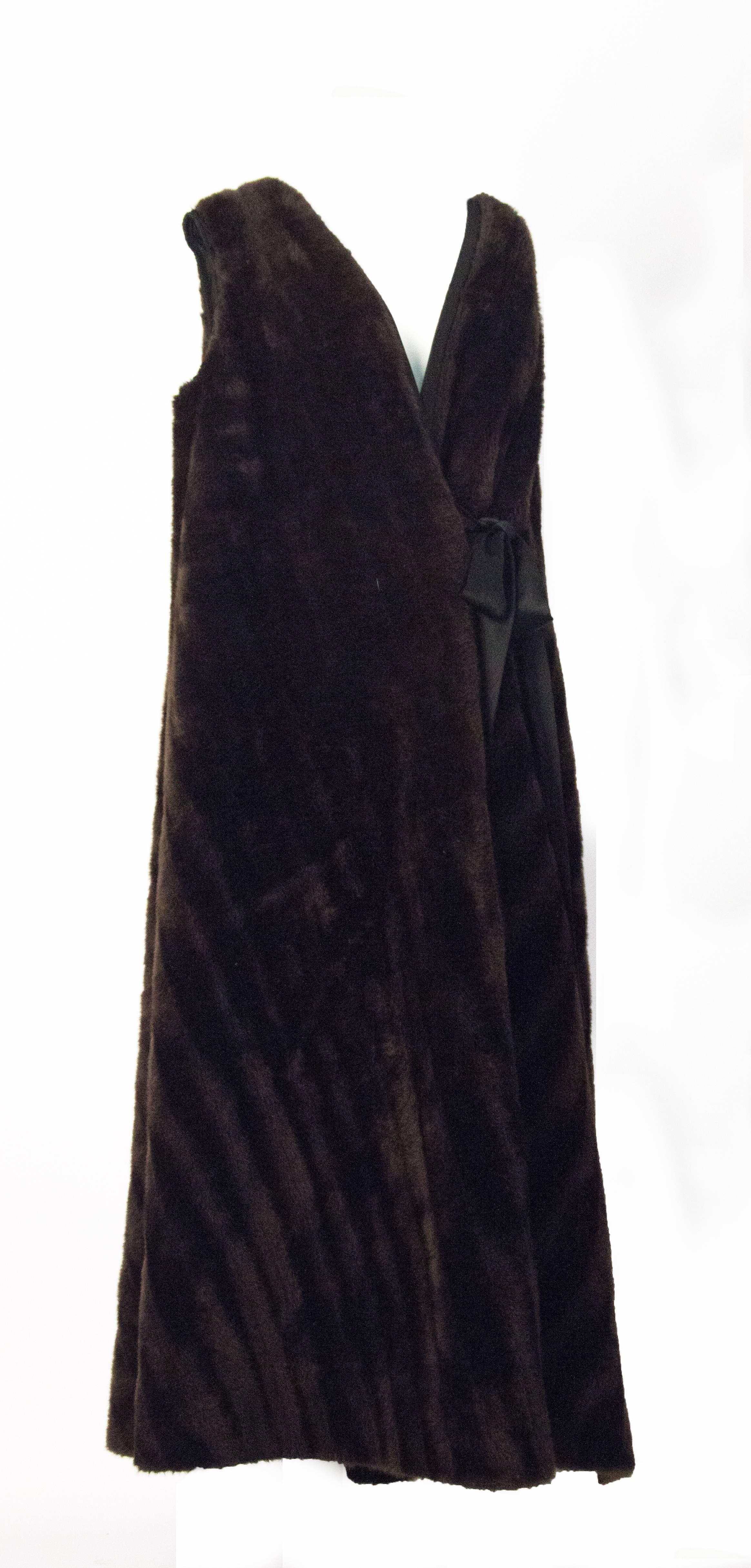 70s dark brown faux fur vest. Wraps around and ties in the front with attached satin sashes. Fully lined. 

