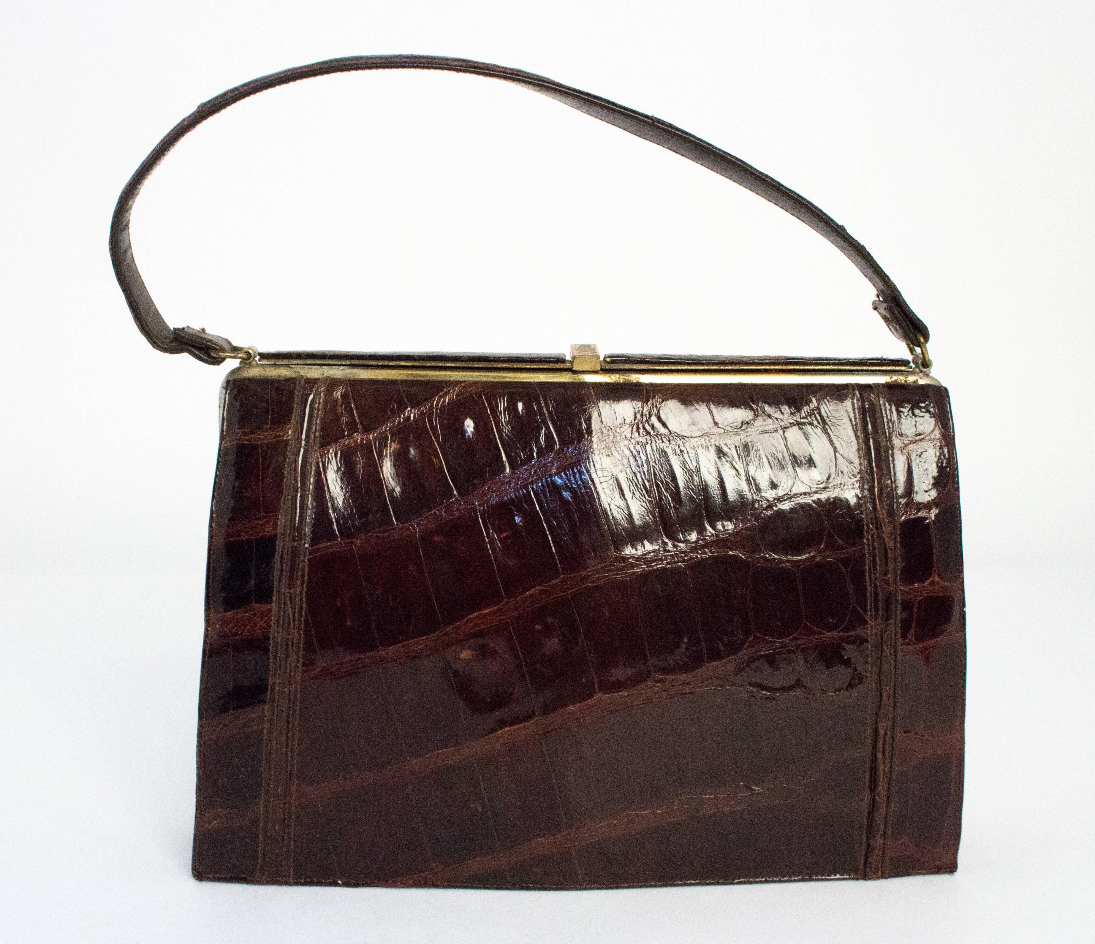 1960s chocolate brown alligator purse. Gold toned hardware. Leather lining. Two side pockets.

Strap length: 17