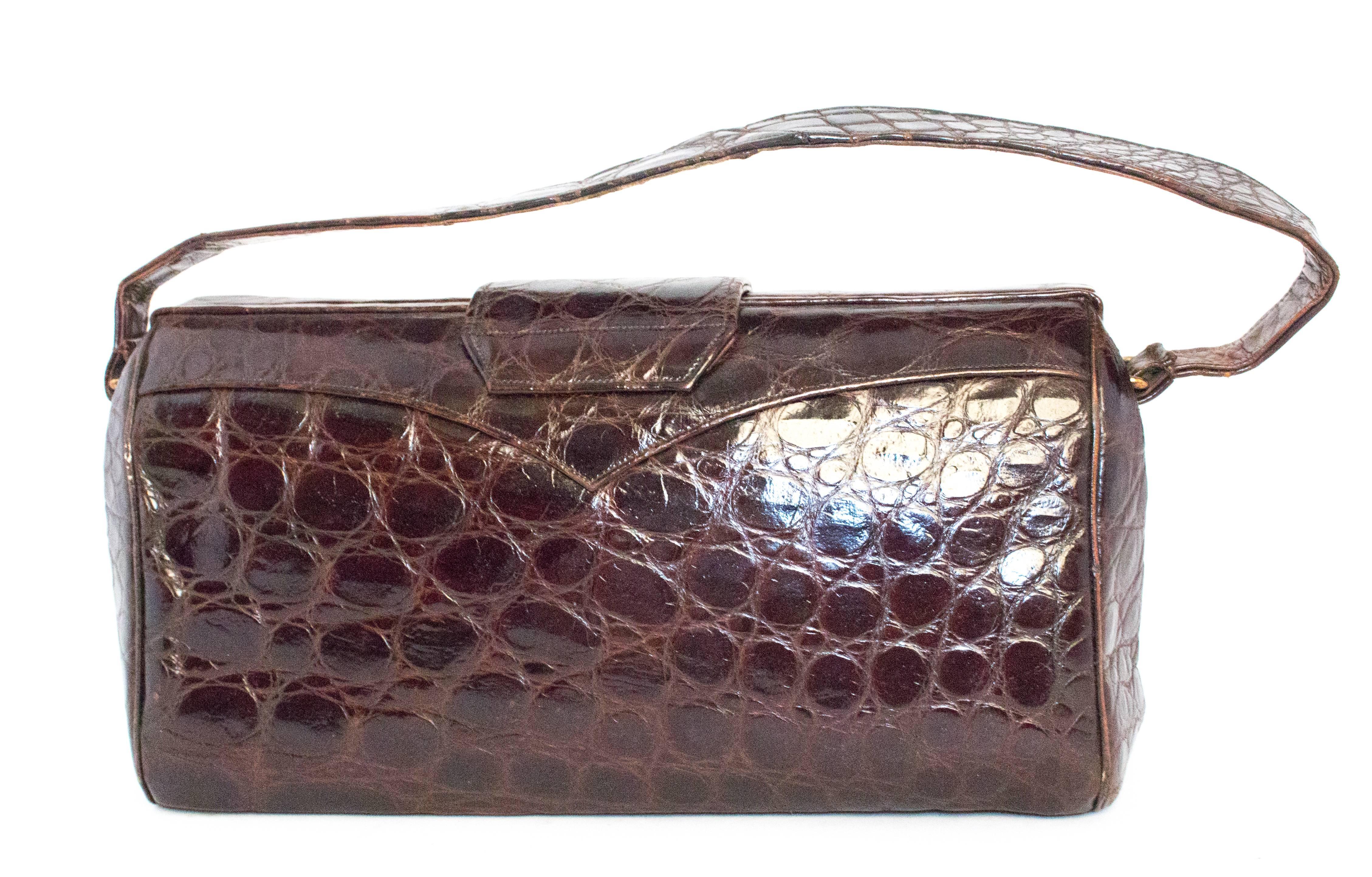 1940s alligator handbag. Opens from top, hinged gold tone hardware. Leather lining. Multiple side pockets. 

Strap: 17"
Purse height: 6"
Purse length: 9 1/2"
Purse width: 4" at base