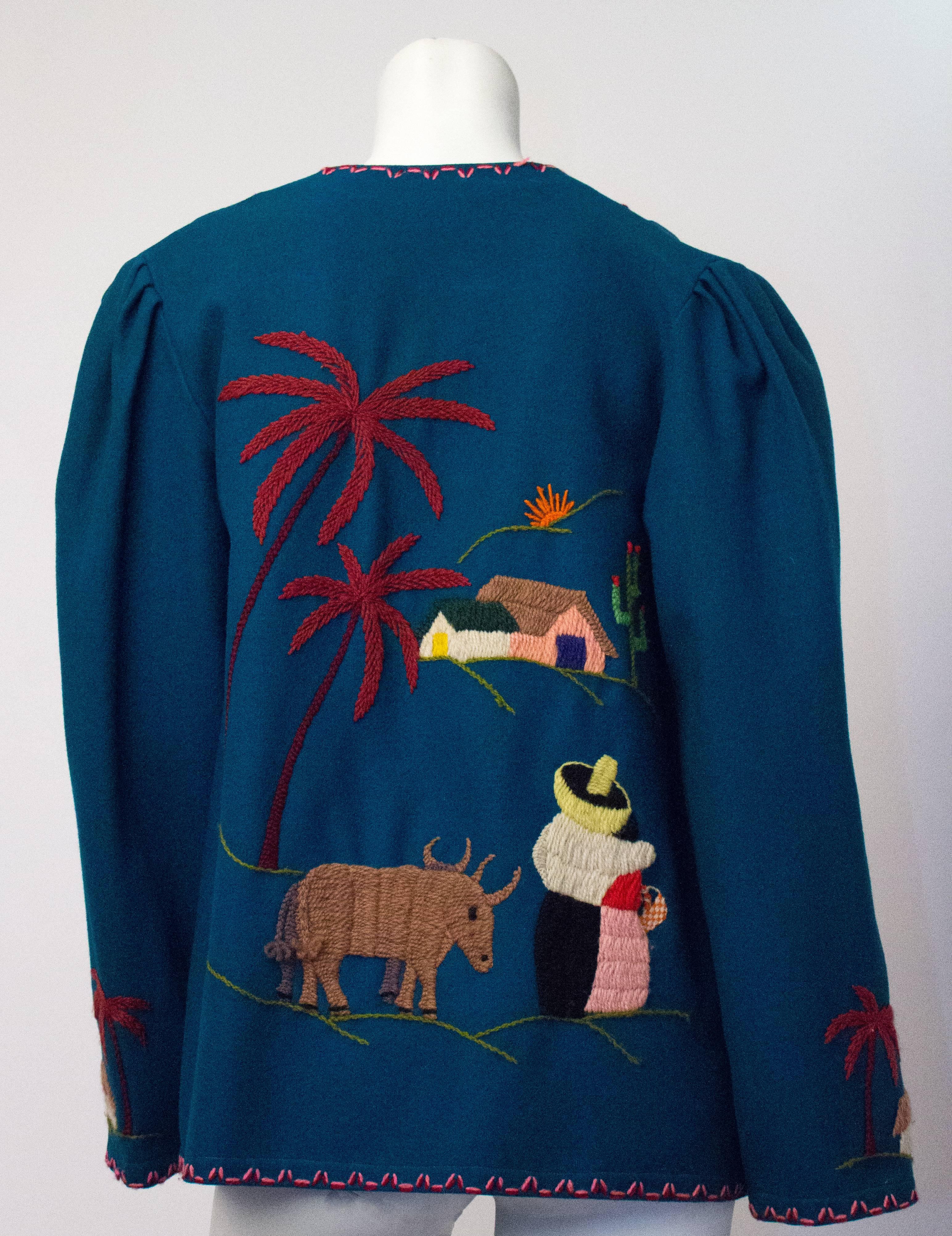 50s blue wool souvenir jacket with hand embroidered scene of palm trees, cactus and bulls. Pleated shoulders. 

