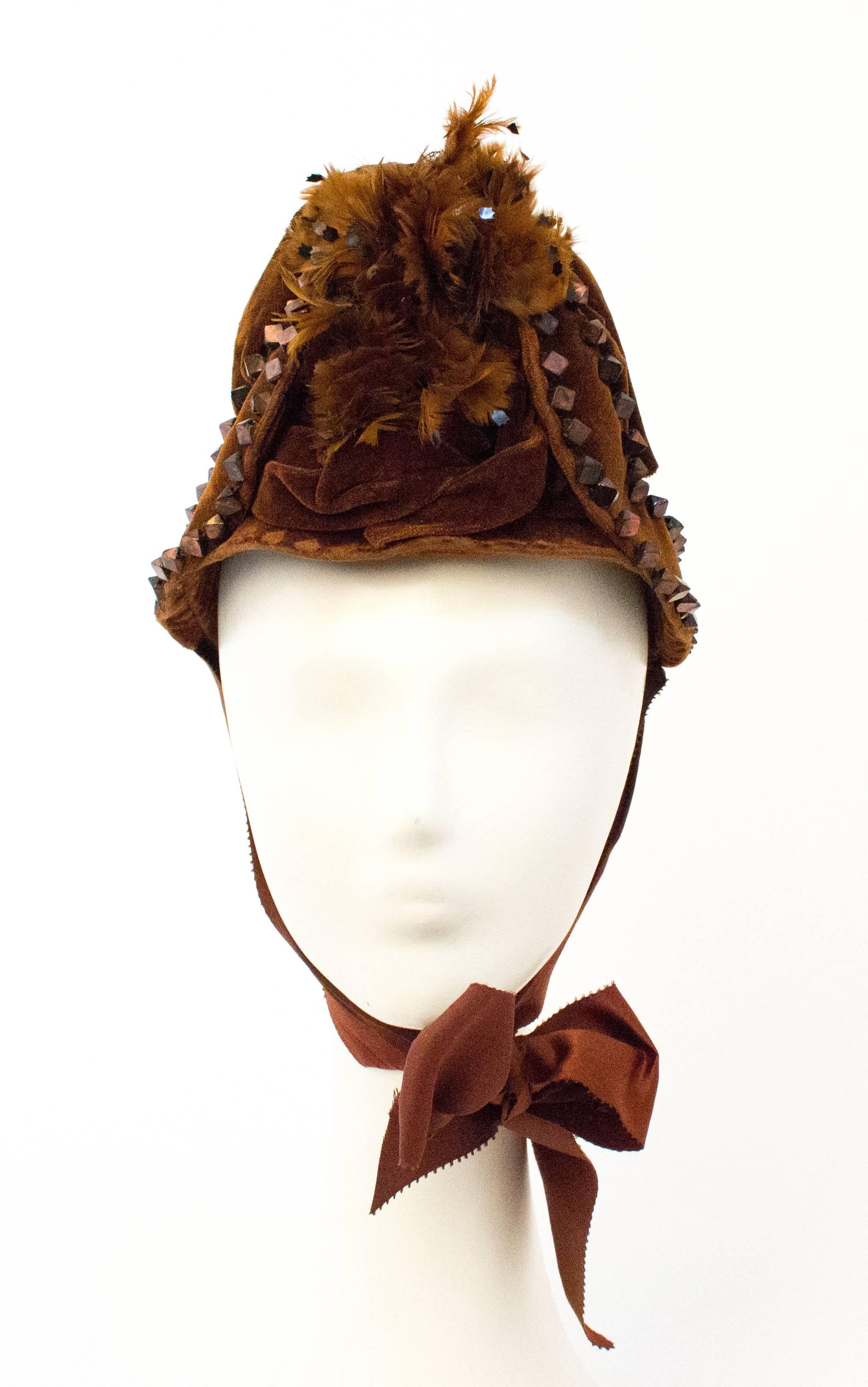 Victorian Brown Velvet Bonnet. Feather and copper colored stud embellishment. Satin ties. Lined.