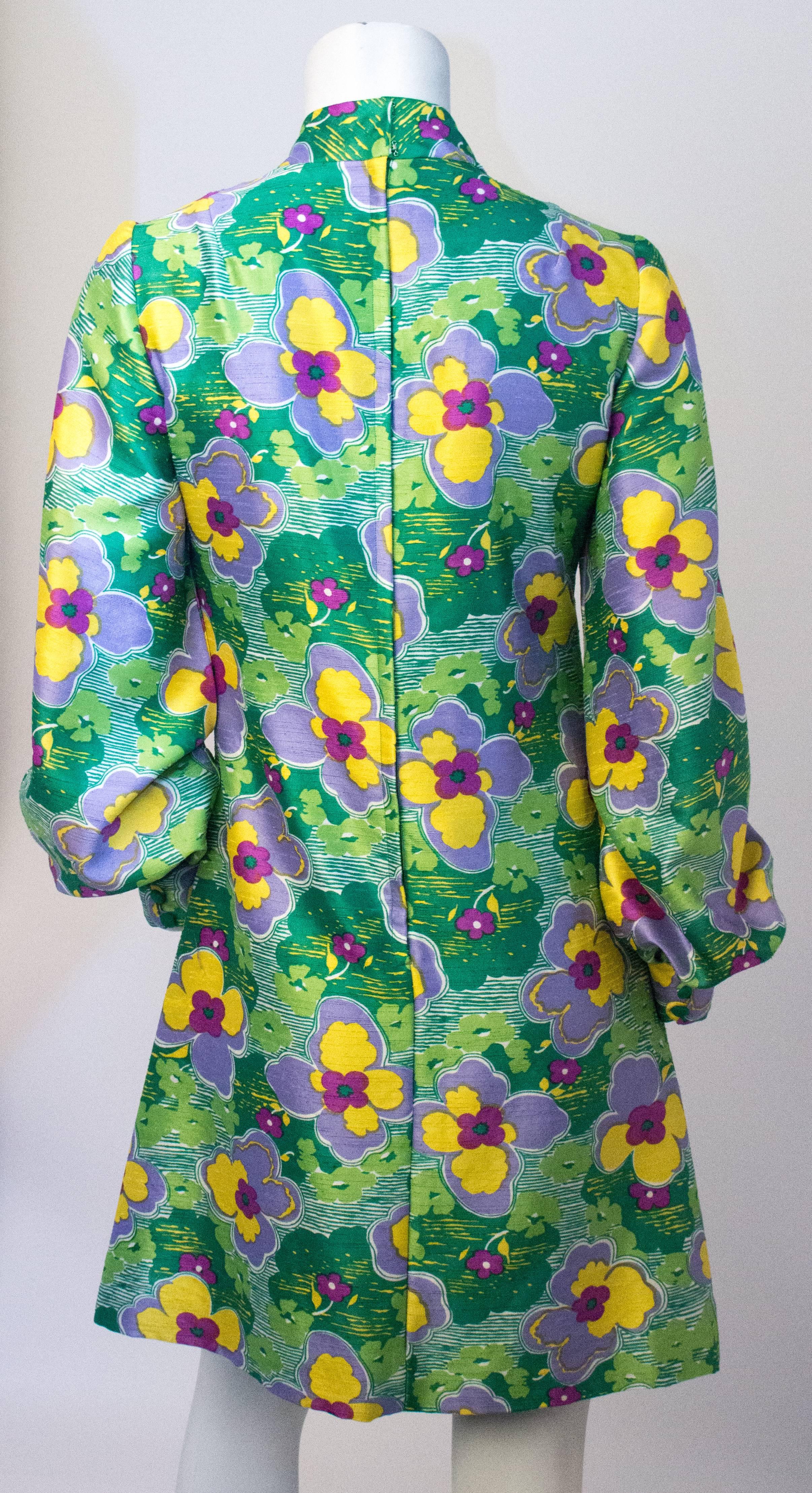 60s Green & Purple Flower Bishop Sleeve Mini Dress. Small slit in center front seam of dress. Sleeves have three covered buttons to open or close cuff. Handmade. Fully lined. Zips up the back. 

