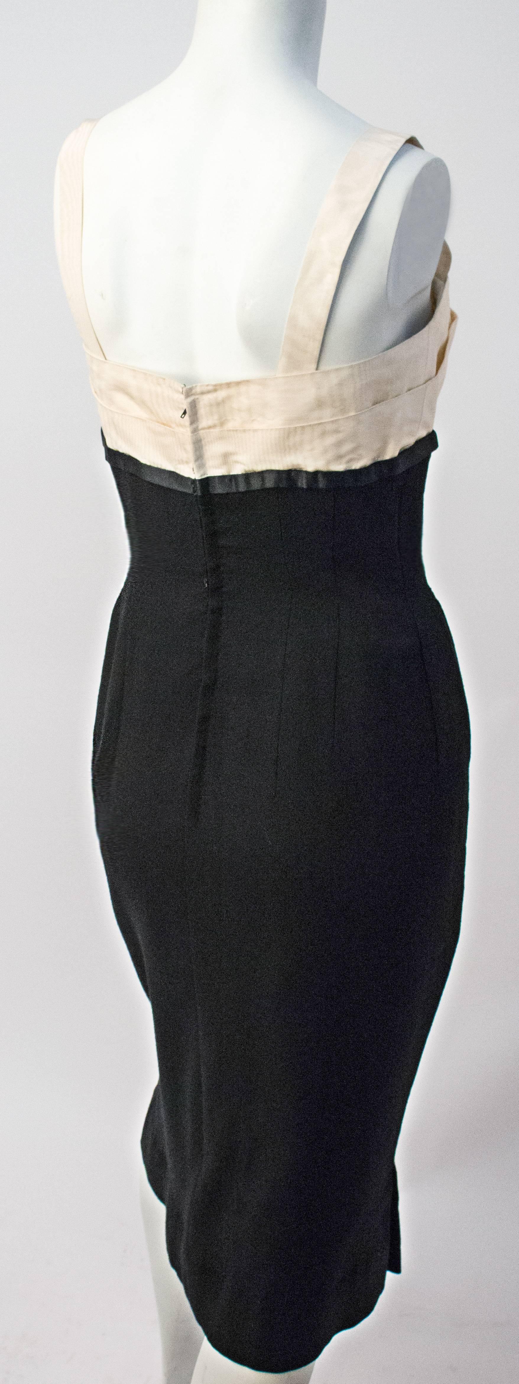 50s Howard Greer Black and White Cocktail Dress. White silk moire bodice, silk satin trim and bow detail at bust. Black wool gaberdine skirt. Fully lined, boned bodice. Hand finished. metal back zip and hook and eye closures. 

Designer to major