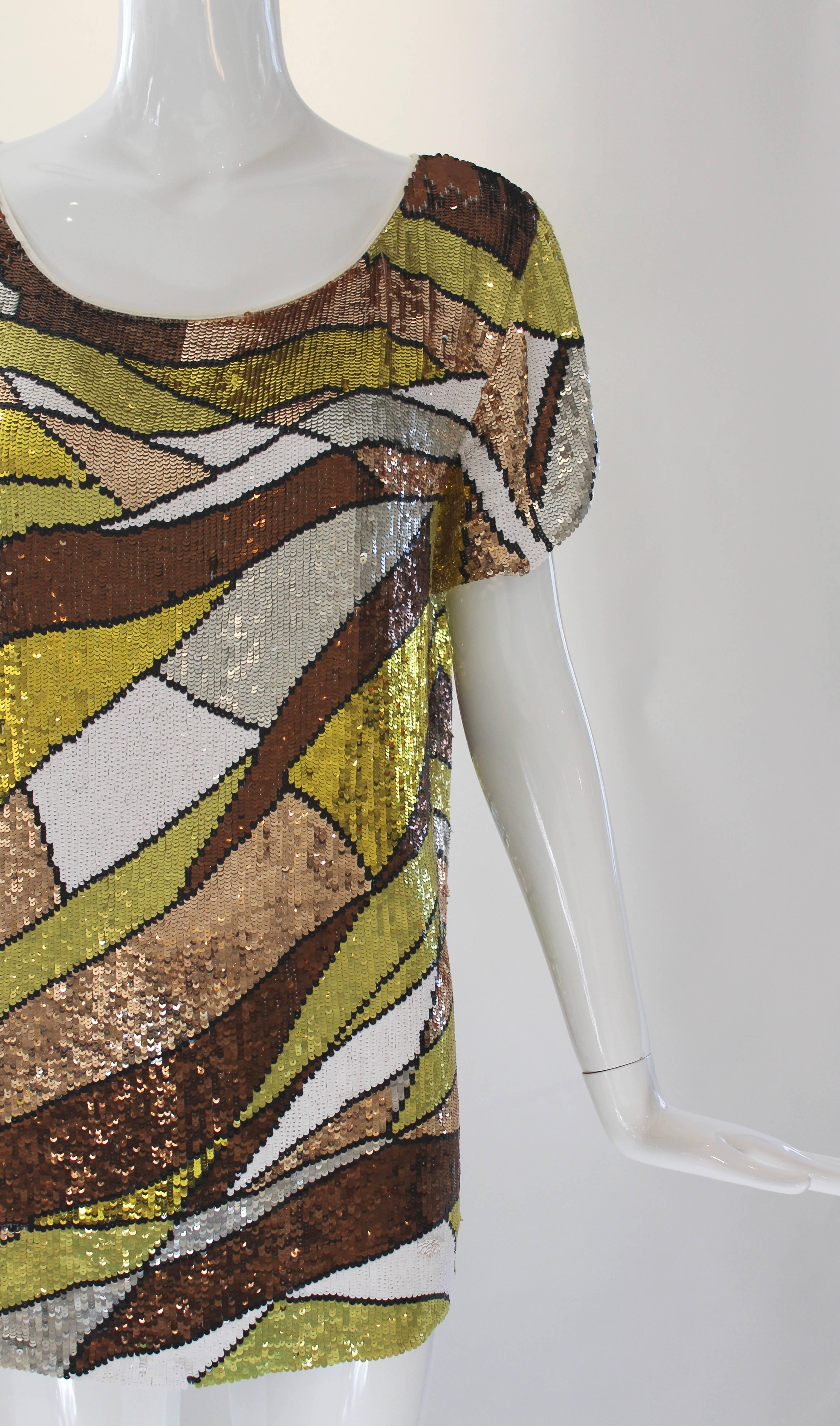 Pucci has done it again with this amazing fully sequined tunic.  Scoop neck, drapey short sleeves and fabulous mod print make it quite the head turner.  Fashioned with copper, white and chartreuse sequins, this tunic would look great paired with