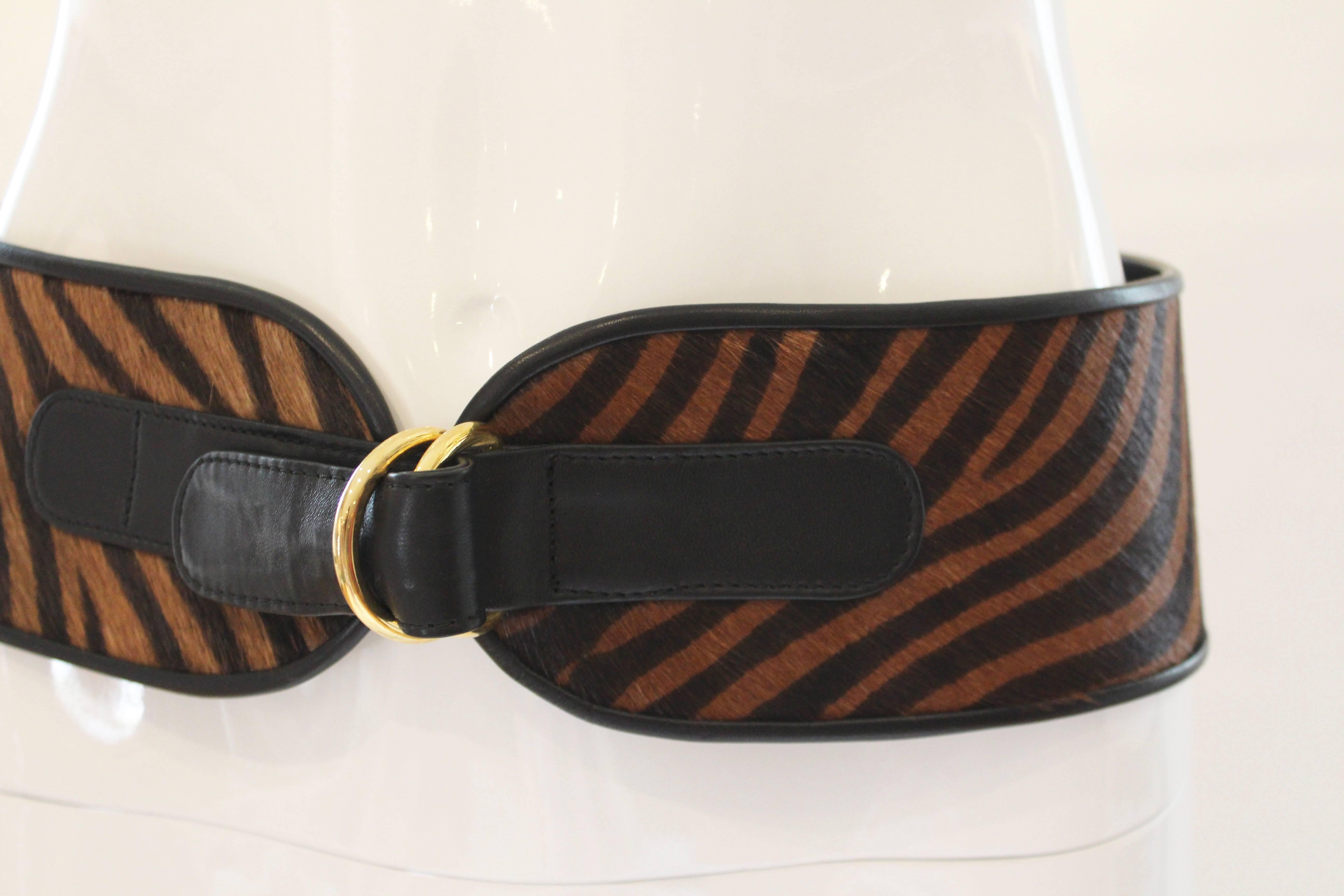 
This fabulous black and brown zebra striped belt will cinch any outfit to perfection.  Makes a bold statement with its generous width and is nicely finished off with leather and gold ring closure .  Truly a great statement belt! 
Measurements in