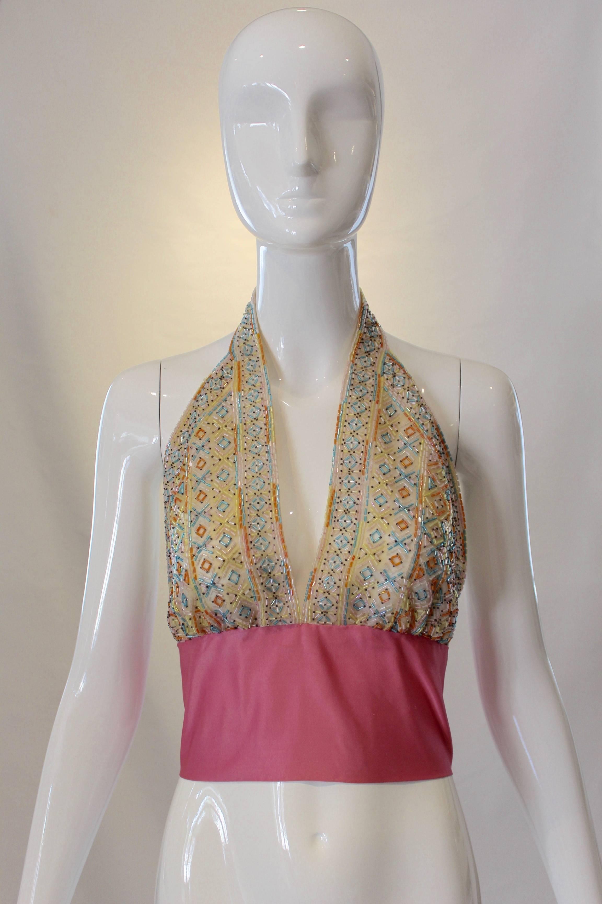 We can’t imagine anything better than this beaded halter top paired with high waisted pants or a skirt for summer! Dedicate beads in shades of blue, orange, yellow and white decorate the halter and a thick pink silk ribbon tied in a bow finishes it