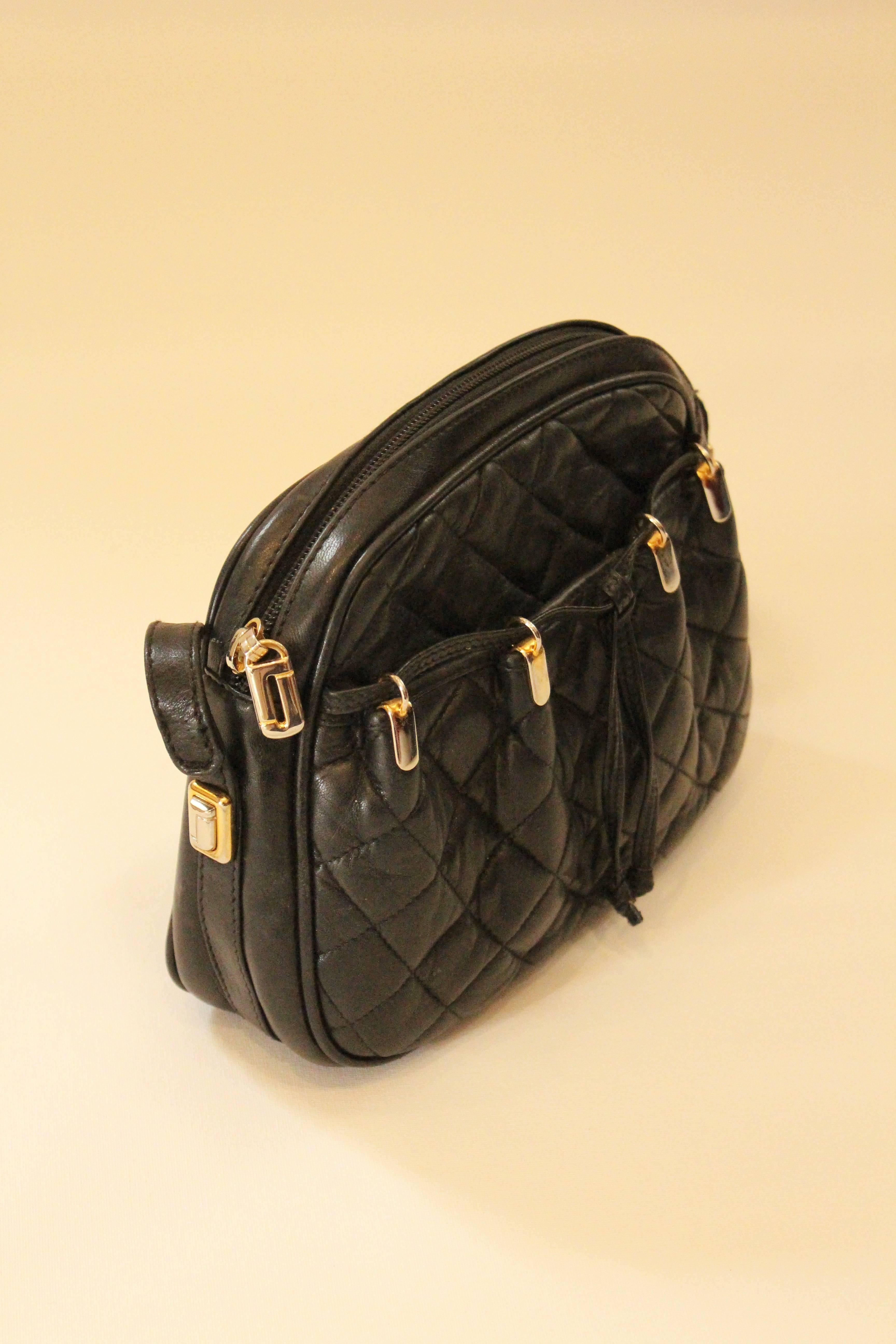 Made from the softest leather, this black, quilted Judith Leiber crossbody bag joins luxury and practicality. Red pebbled leather interior. 

Zip pocket and front pocket. Drawstring and tie detail on front. Gold hardware. 

Made in Spain. Strap