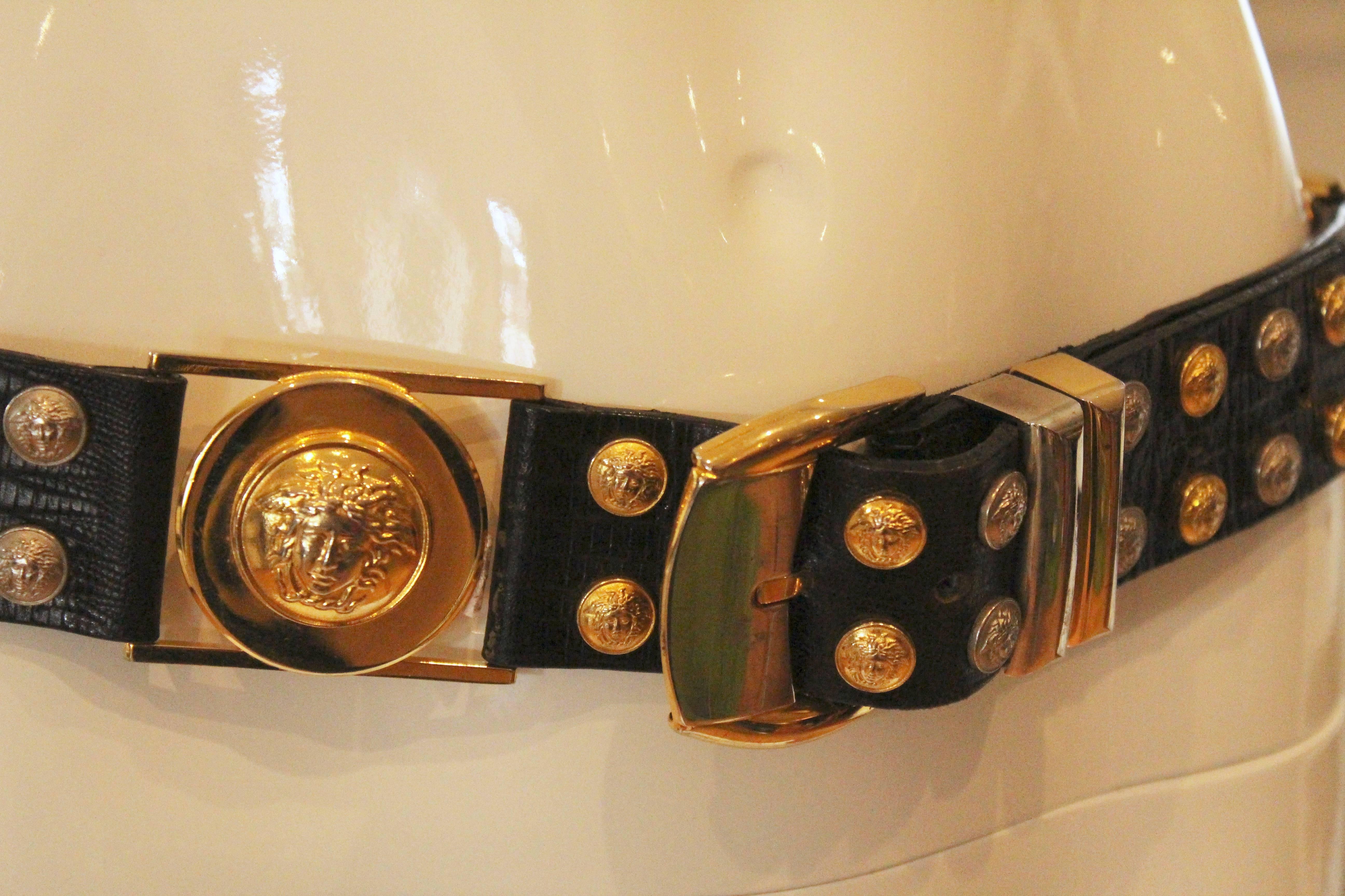 Cinch your outfit with this fabulous Medusa Head Versace Belt.  Fashioned of high quality snake embossed black leather with black and gold small stud like medusa head embellishments.  The couture quality of this belt and high fashion look will