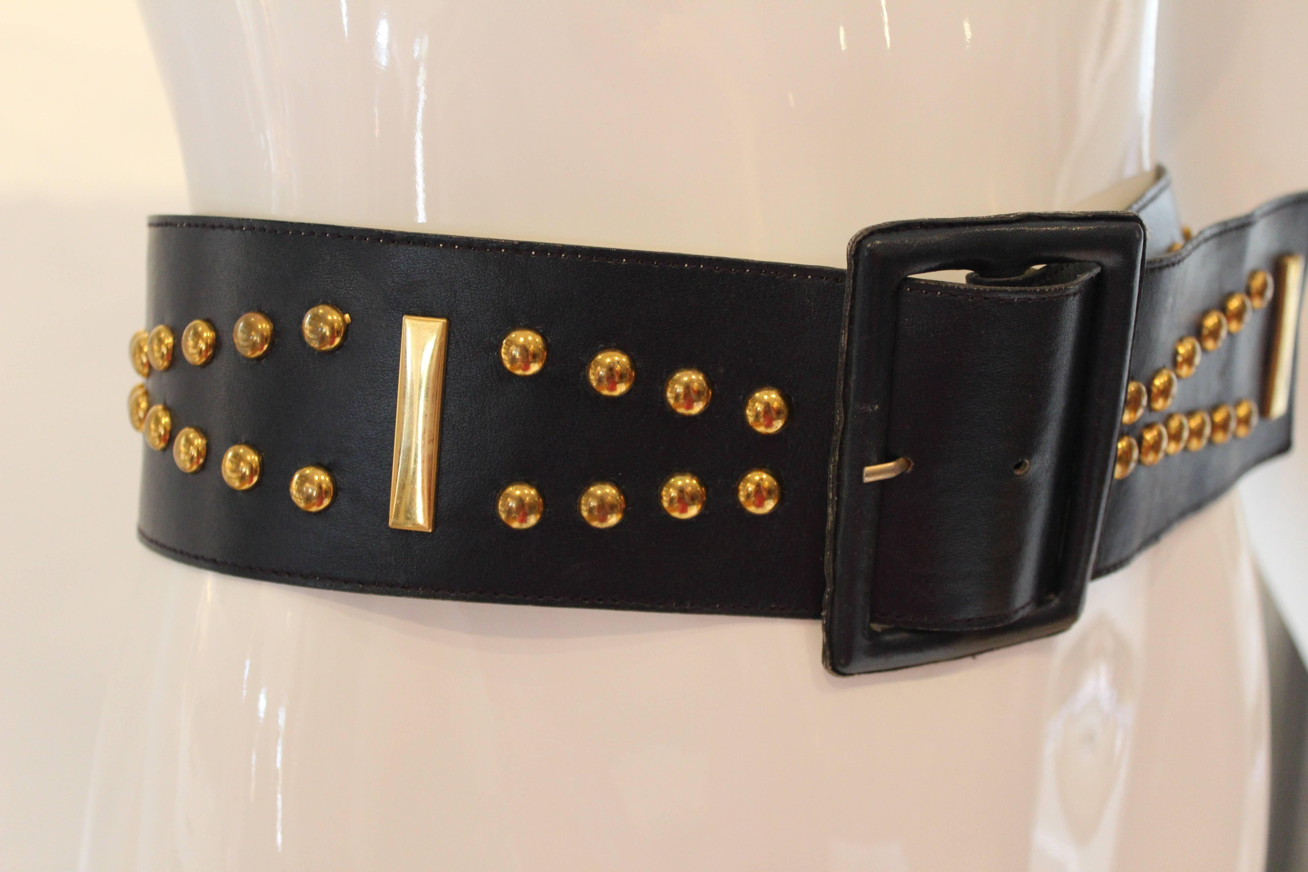 Cinch your waist with this classic YSL navy leather belt.  Gold tone studds in geometric pattern add visual interest.  A collectible piece that is a versatile wardrobe addition.

Size Large
Length: 33