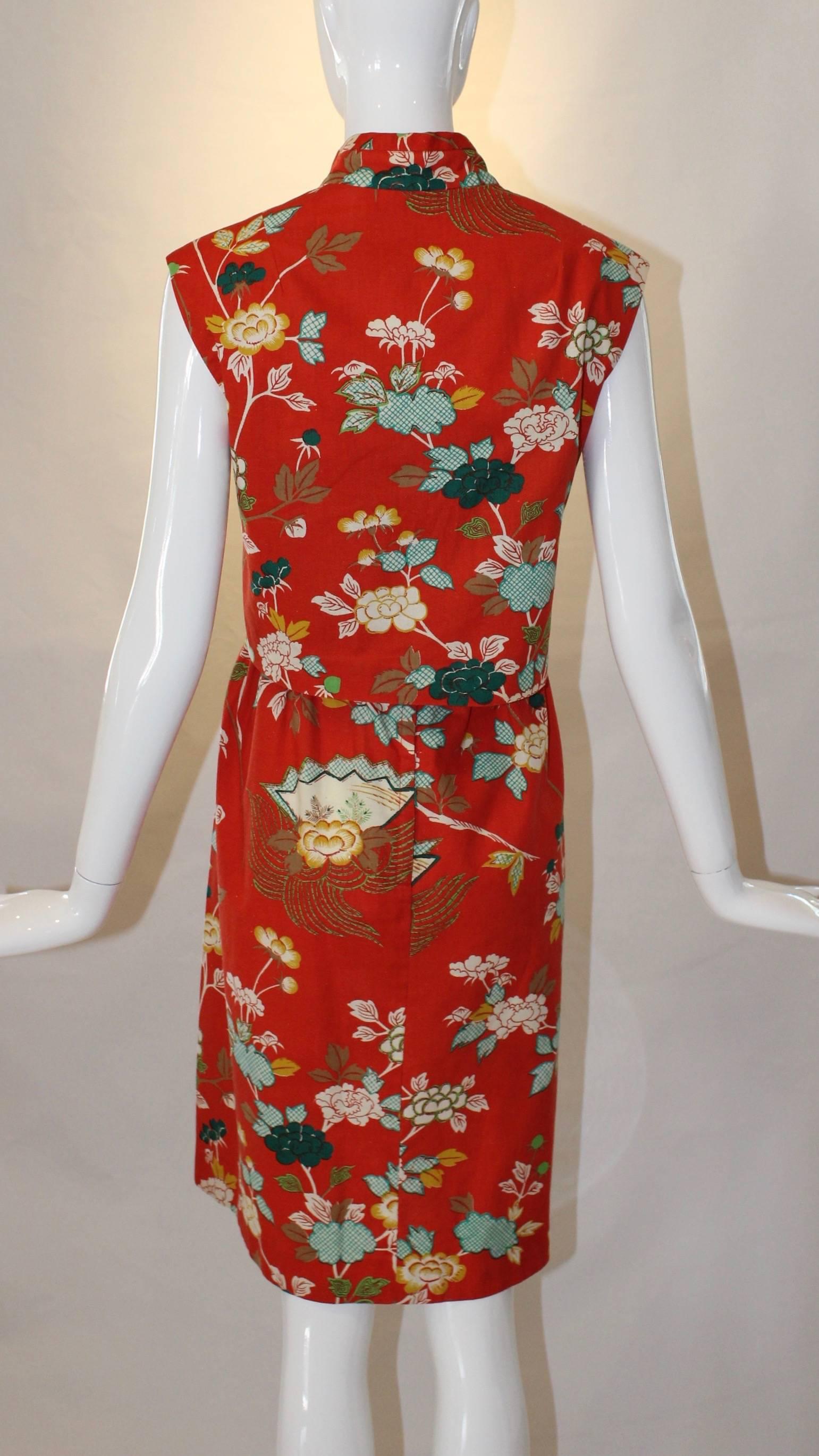 This adorable printed 1960s Two Piece Sundress Set from Neiman Marcus is right on trend, even fifty years later! A red, blue and yellow floral print decorates this adorable dress and a Mandarin collared cropped topper finishes it off. 
40”