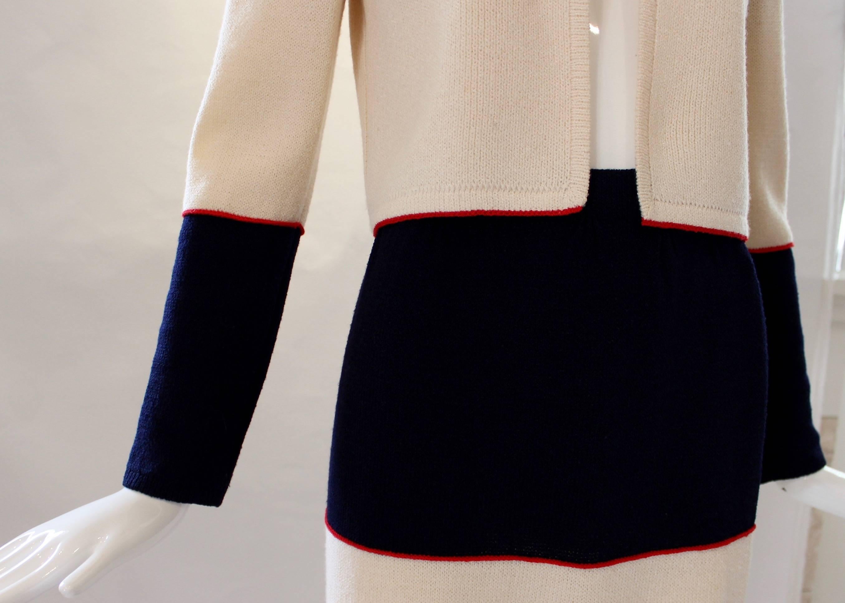 Shades of navy blue, cream and a red trim decorate this vintage two piece set from St. John. An adorable and rare vintage find, the sweater has a clasp at the collar and padded shoulders while the pencil skirt features an elastic waistband and falls