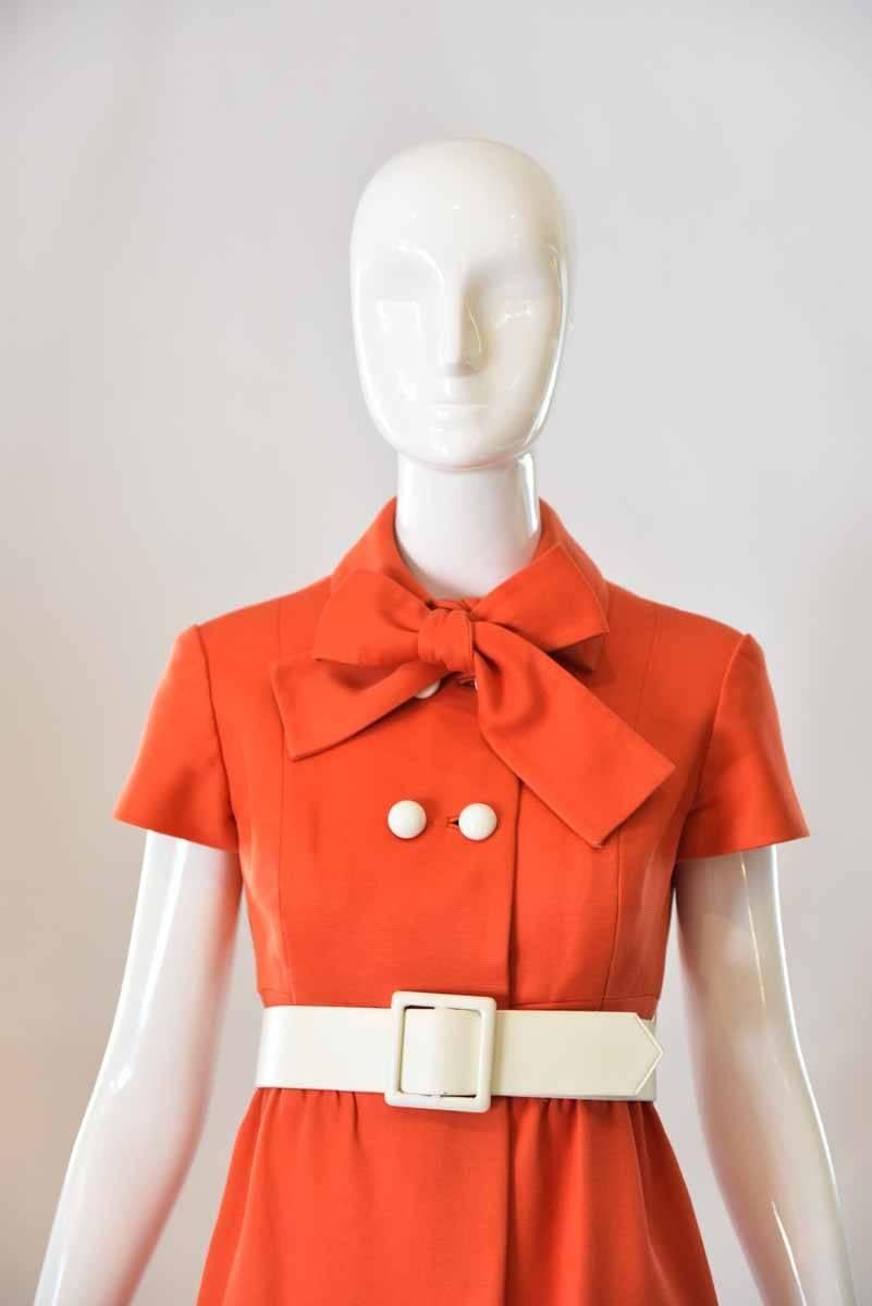 A tie at the neck and bold white buttons at the top of this adorable 1960's Geoffrey Beene Dress set this dress apart from the crowd! This fit and flare dress is cinched at the waist with a white leather belt and features large pockets at the front