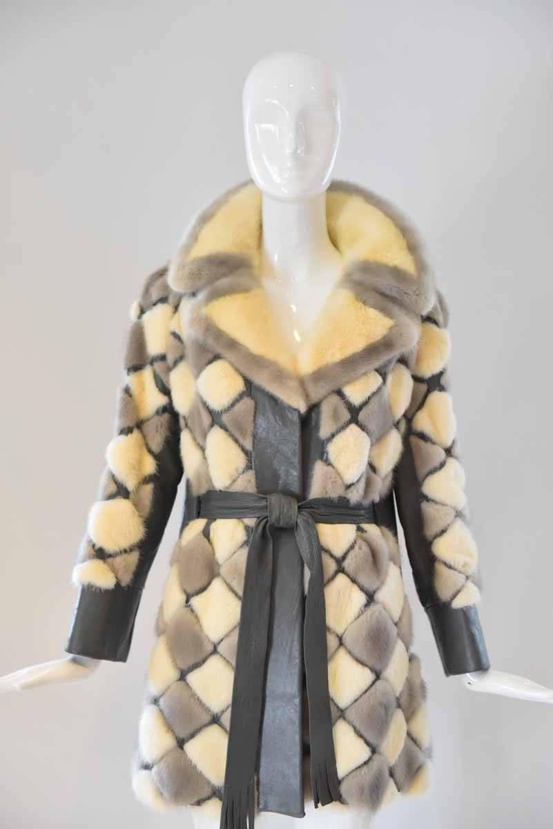 Embrace the chilly weather with this oh-so-stylish vintage fox fur and leather coat by Wurzburg Grand Rapids. Small patches of white and gray fox fur decorate this gray leather coat. An oversized collar and a leather sash to cinch the waist finishes