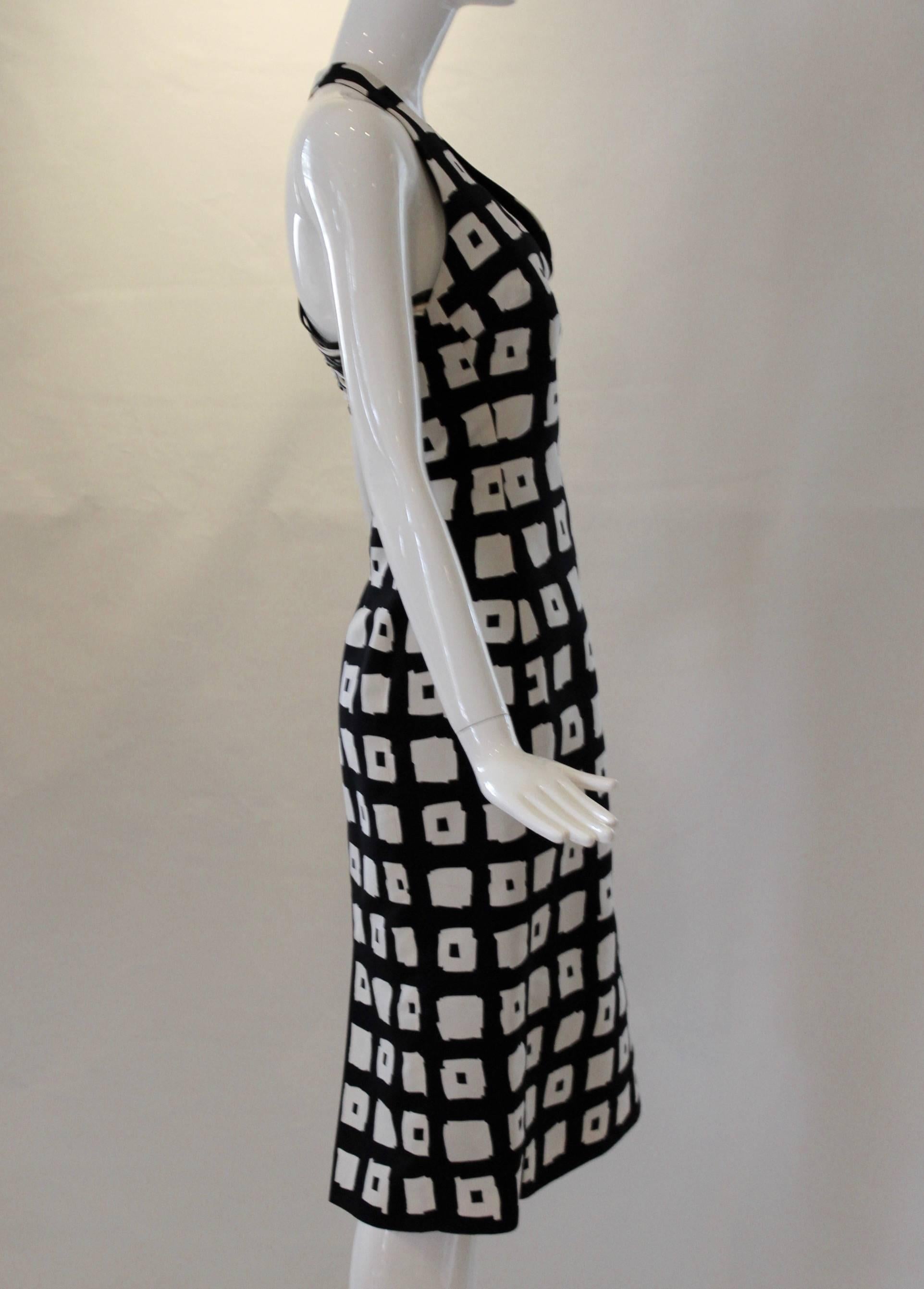 This bold 1980s black and white Gianfranco Ferre dress will stand out from the crowd at your next soiree! This silk halter party dress includes a v-neckline and intricately braided black & white leather details at the back. 

- Length: 43