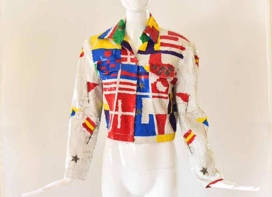 This fabulous vintage 1980s Lillie Rubin jacket features all-over sequins in an eclectic and colorful print. With stars, stripes, and pearl accents, this jacket would look great layered over a simple tee, chambray top, or a knit dress. The