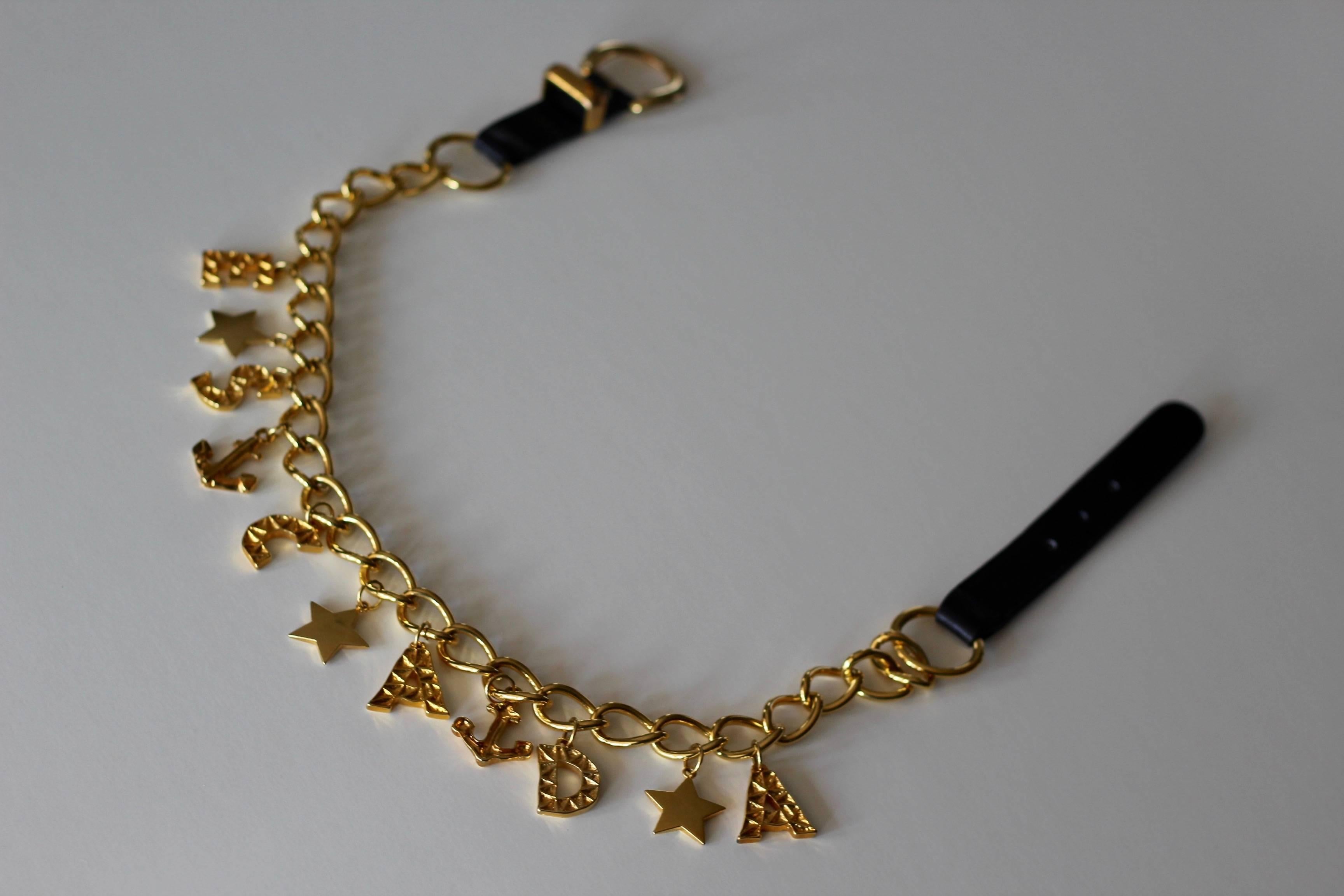 Add some pizazz to your look with this fabulous Escada Gold Chain Link Belt! This monogrammed belt spells out ESCADA and features nautical elements including stars and anchors. Belt features large gold chains and is finished with a black leather