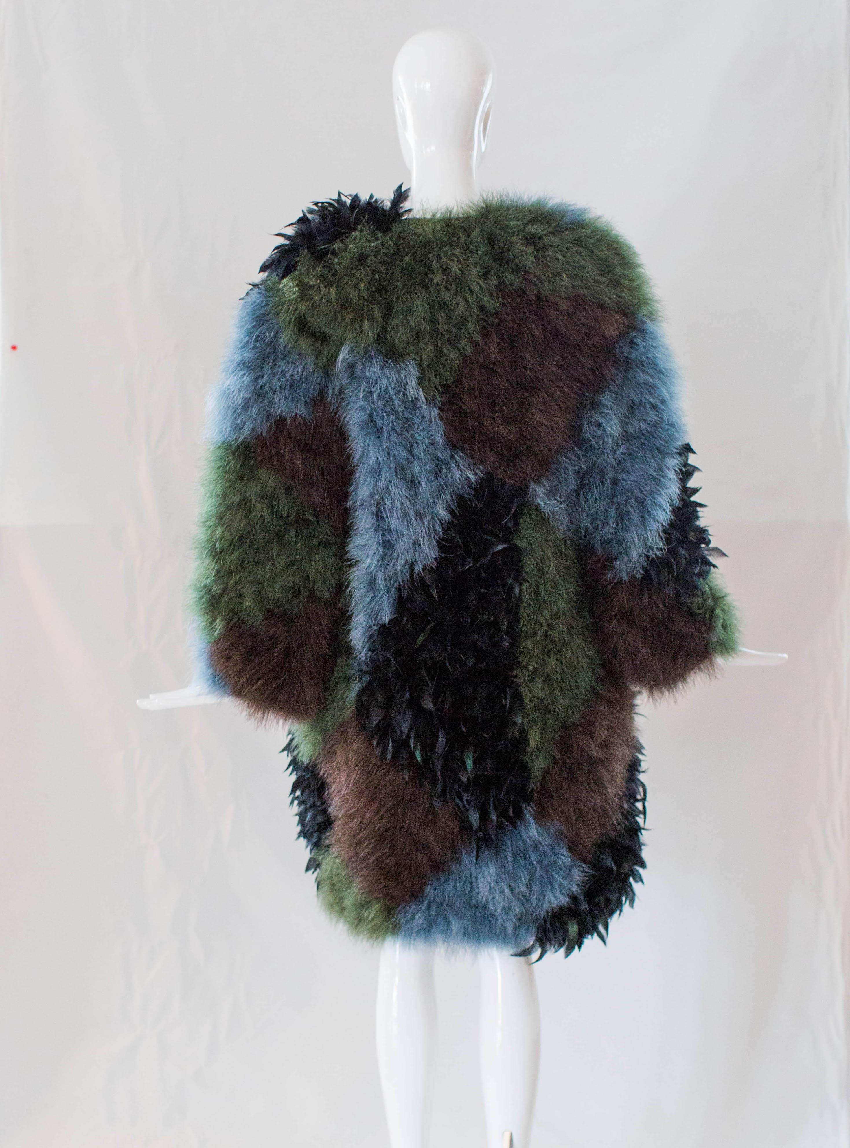 This fabulous Marabou Feather Coat is dotted with black, blue, gray and green feathers. Lined with brown silk and finished with black buttons at the front, this coat will keep you stylishly warm this winter! 
Length: 41” 
Chest: 38” 
Sweep: 40” 