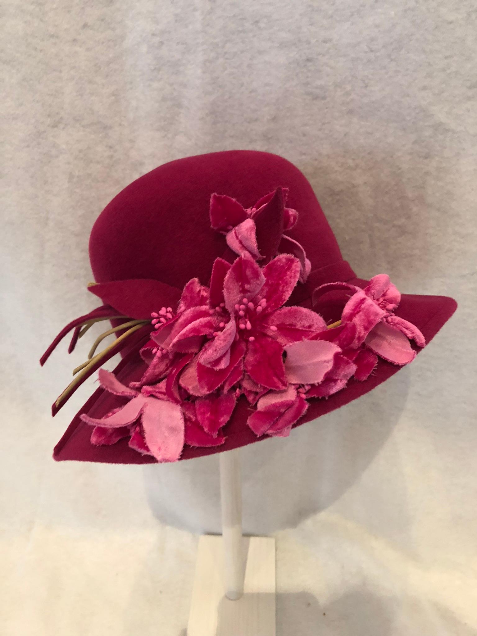 Turn heads in this stunning Frank Olive fuschia hat embelleshed with velvet flowers and leaves.  From the Private Collection, this hat is in great condition and would complement any fashionista's wardrobe.  Inside hatband measures  22