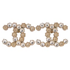 Orecchini a bottone Chanel con logo CC in oro rosa e strass, realizzati in Francia