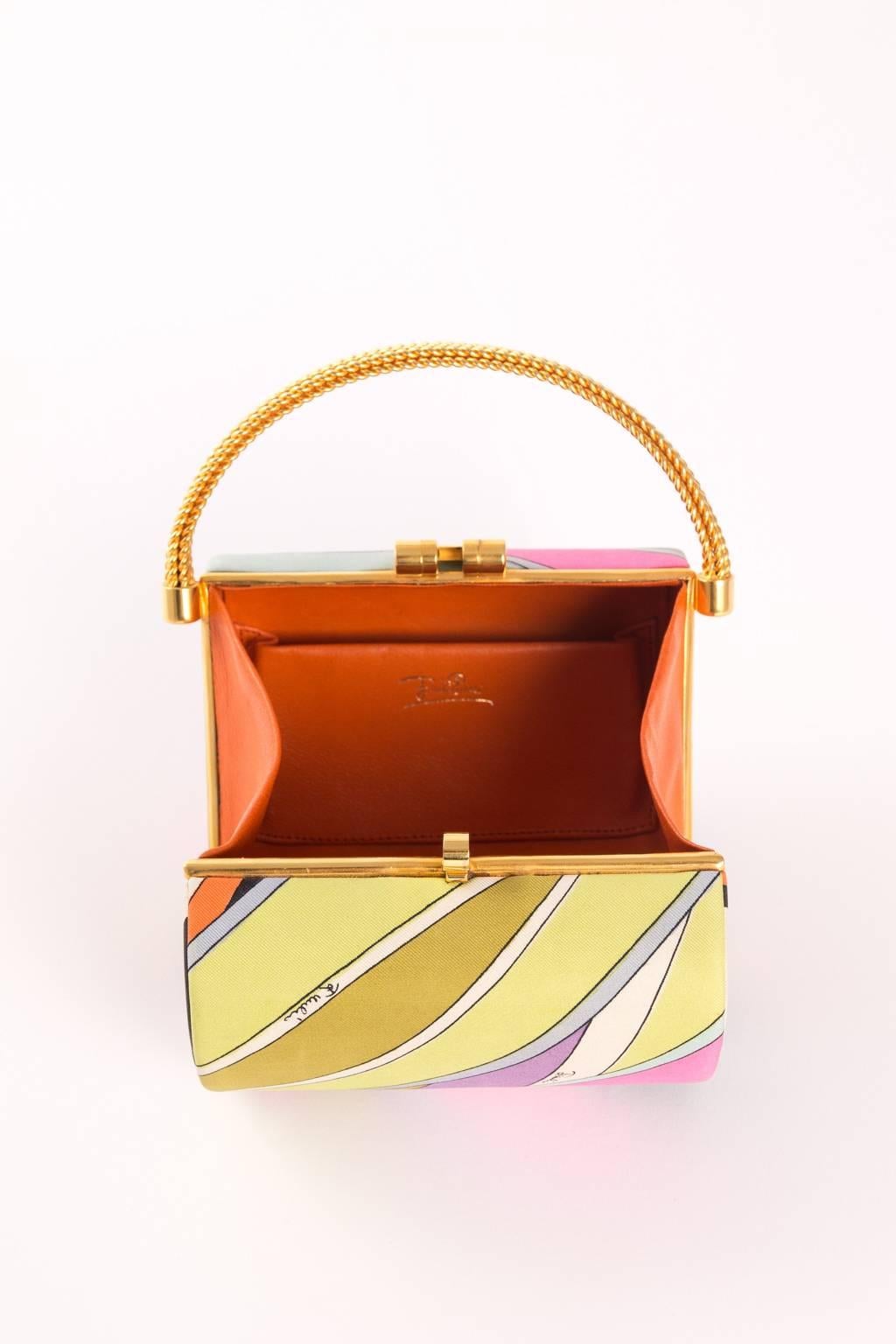 funky finders has this iconic handbag from the house of emilio pucci. features a signature, signed, silk-blend midcentury print. 3-tier decorative brass handle & 4 brass feet are noteworthy. beautifully designed brass closure. the 'box' bag remains
