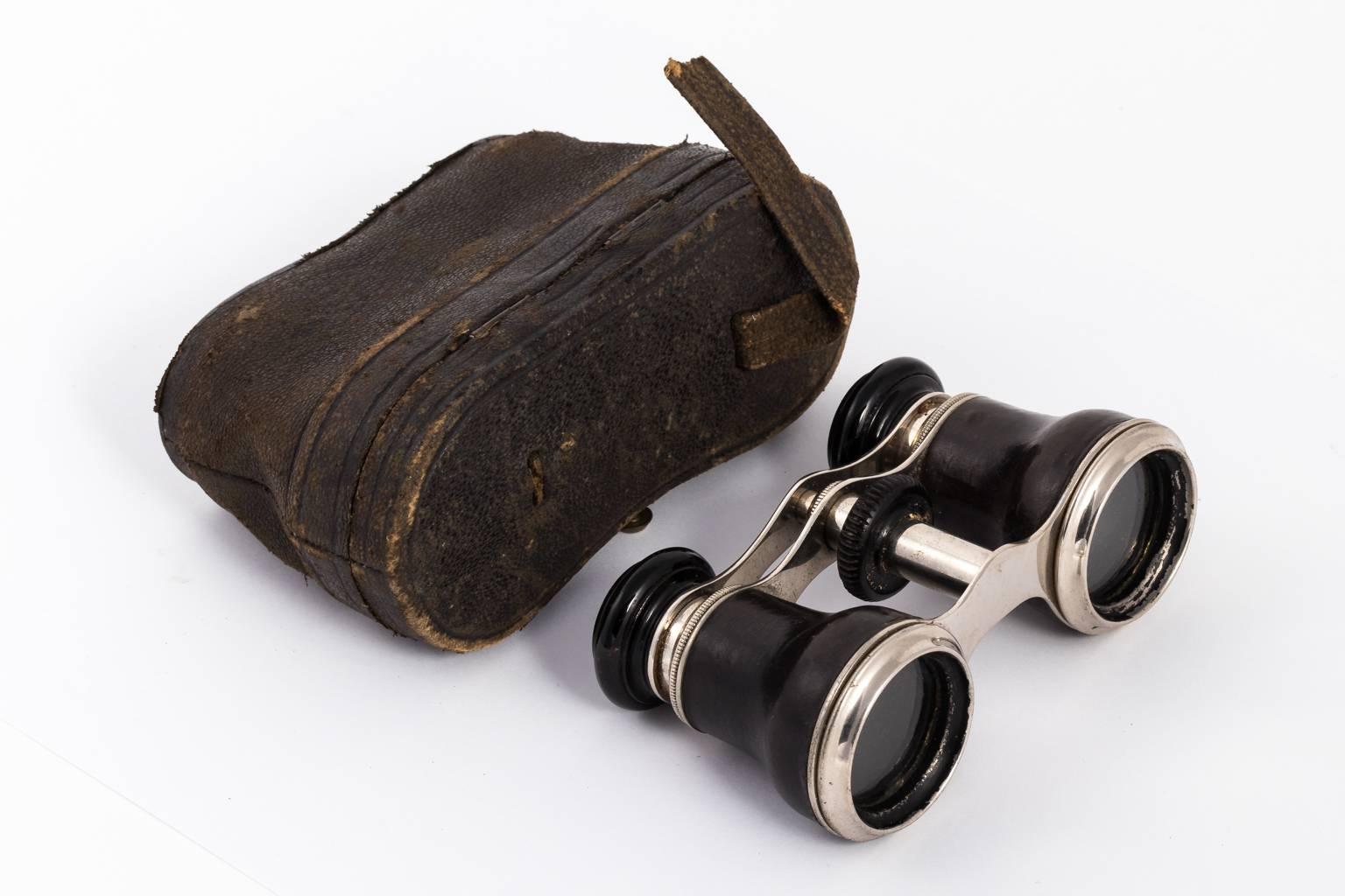 Circa early 20th century Leather bound opera glasses in a polished metal finish with matching box.