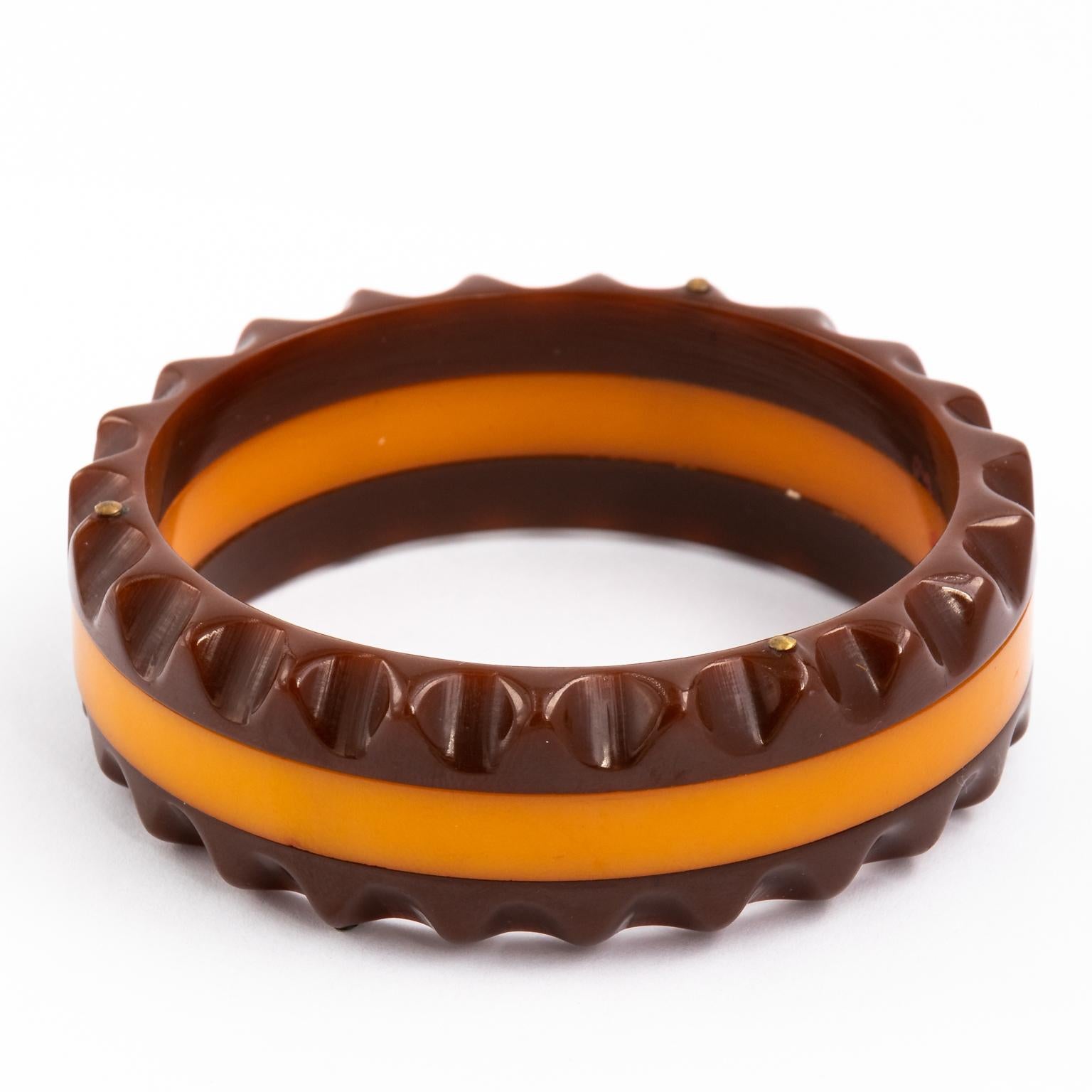 Circa 1930 Art Deco butterscotch maroon bracelet in Bakelite. It is almost one inch wide. It has a saber tooth style edge on both sides.
