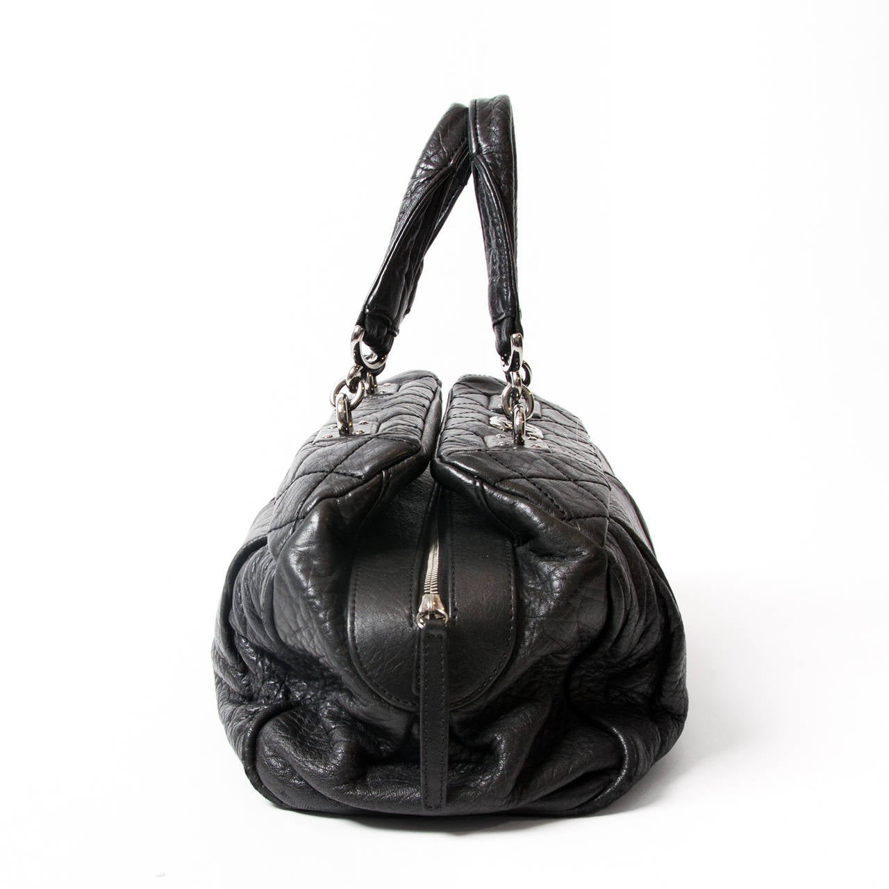 Chanel Black Doctors bag, Made out of black leather with the iconic diamond shaped stitching. There is a silver CC on the front of the bag. 
 The bag has a zip top closure. The interior has a silver leather lining and features a zipper pocket,