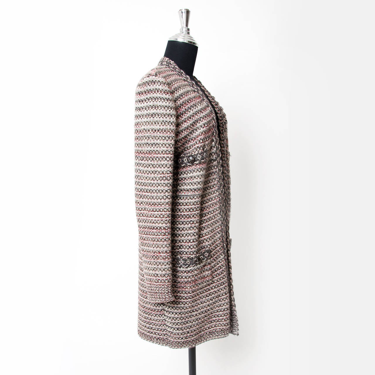 Long Chanel cardigan made form boucle wool. Muted red, grey and blue wool and a delicate gold metallic thread are woven to make the typical 'bouclé' pattern. 
The cardigan has an open front, no buttons or hooks.