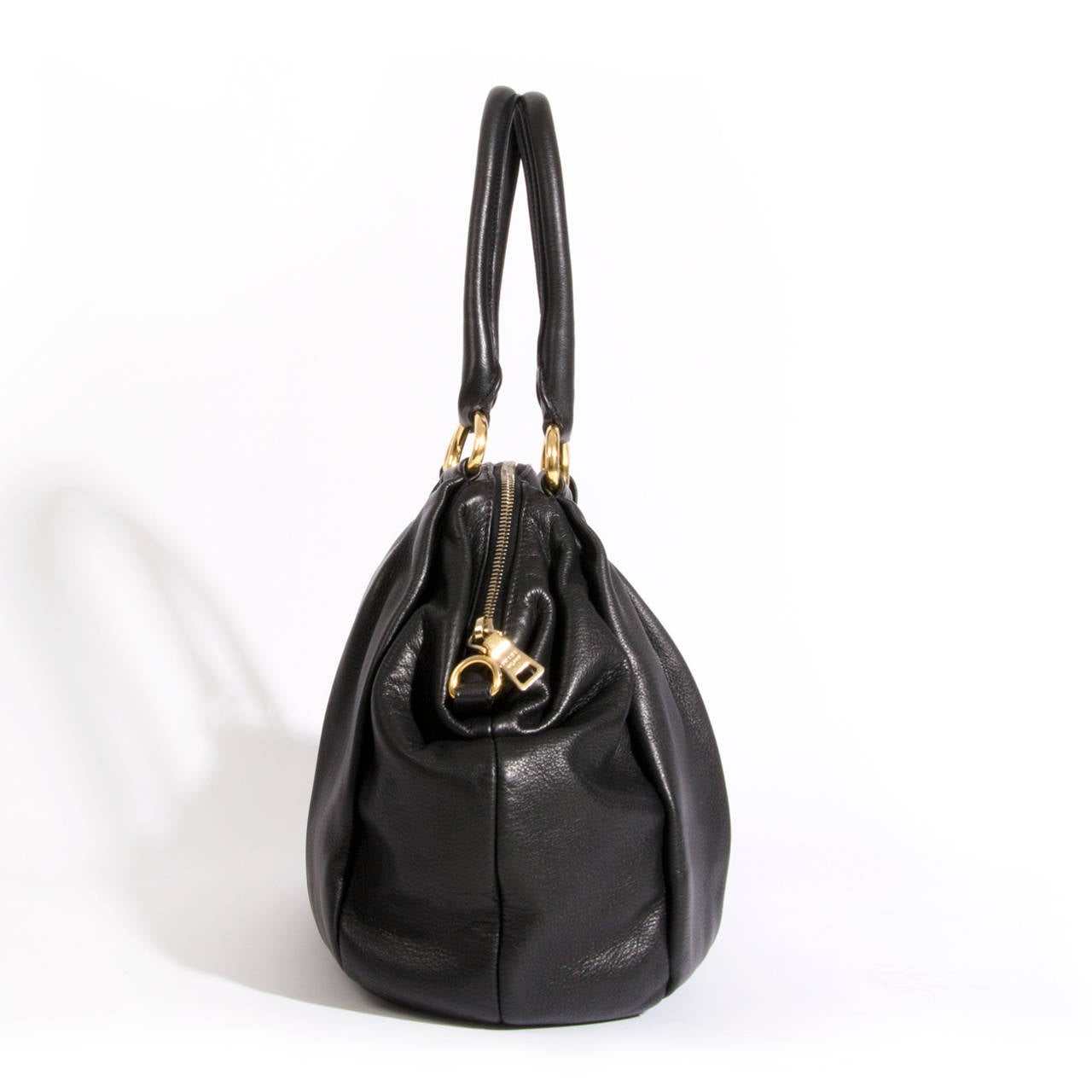 Prada black leather top handle bag with golden hardware, gold zipper closure. 
Black prada linning with one open pocket and one zipper pocket. 
Comes with dustbag.