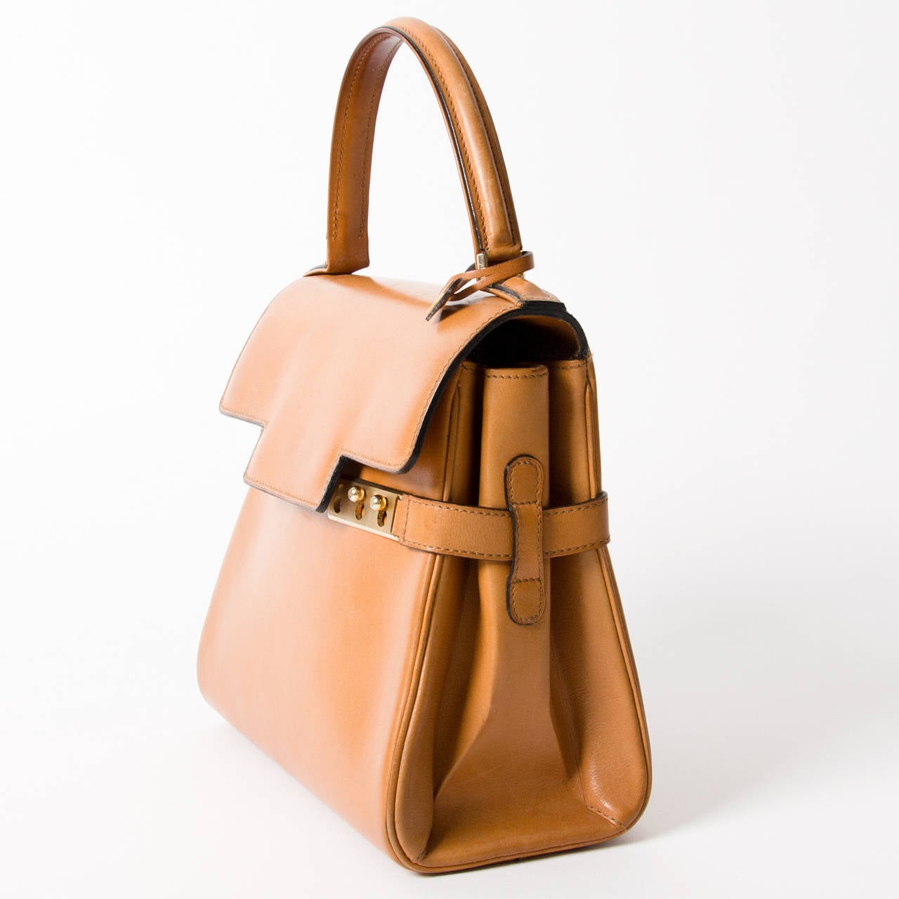Vintage Delvaux Tempête cognac bag with gold hardware. With its statement hardware and geometric shape, this beauty is one of Delvaux's most architectural bags. 
Comes with Delvaux authenticity card.