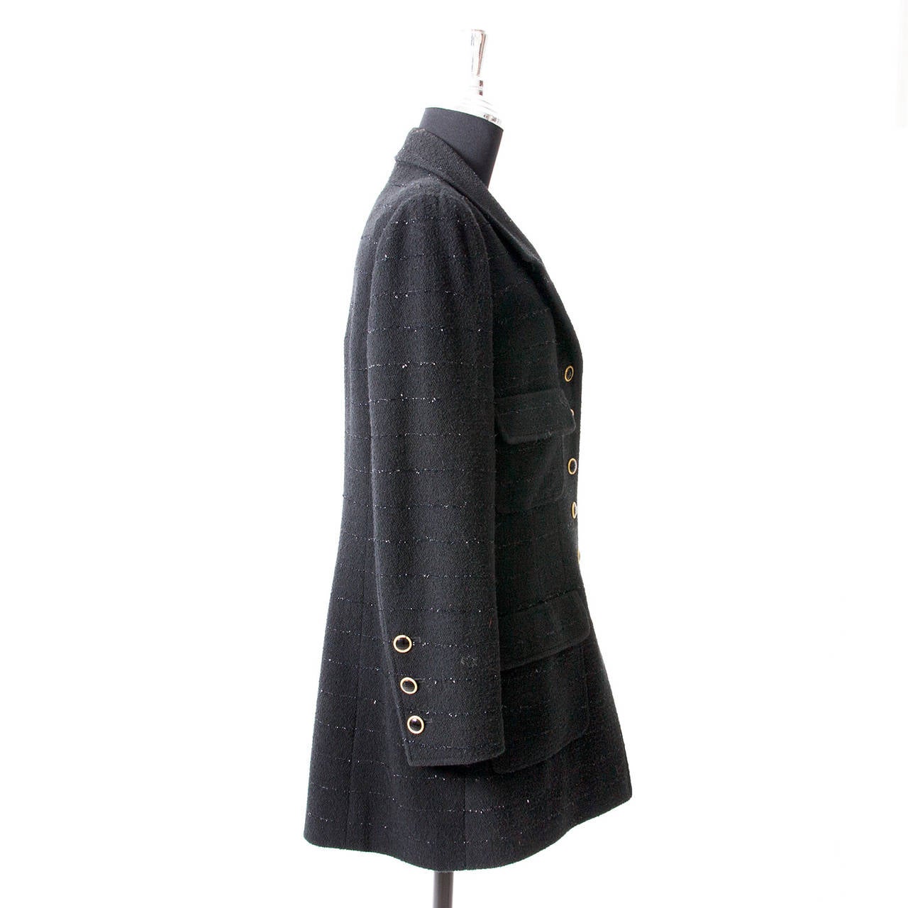 This Chanel jacket comes in a beautiful black tweed fabric, with a glittery veining as a subtle but refreshing detail. Notice the luxurious black buttons along the front, decorated with a gold edge. The classic cut of this jacket makes this timeless