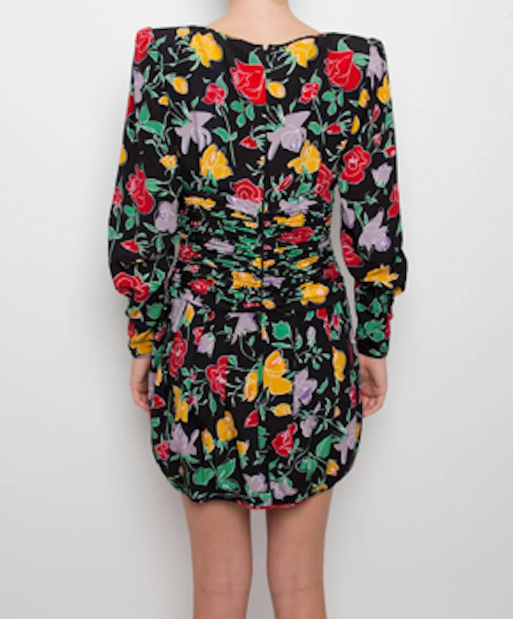 Ungaro dresses are known for their flamboyant patterns and elegant draping with an emphasis on the comfortable and flattering encasement of the female form. These dresses are truly vintage pieces. 
Black dress with red, yellow and green rose print.