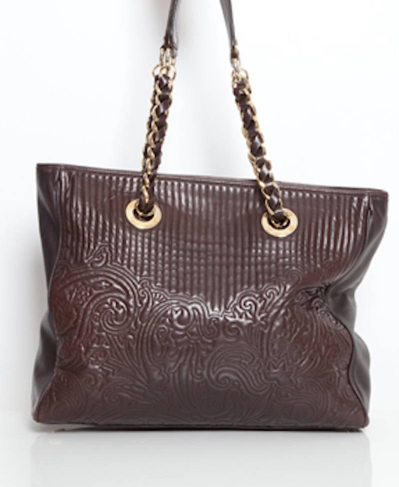 Add an extra touch of class to your everyday outfit with this elegant and stylish chocolate brown leather shoulder bag by Etro.
The leather is stitched with an original flower pattern and the leather shoulder straps are complemented with gold toned