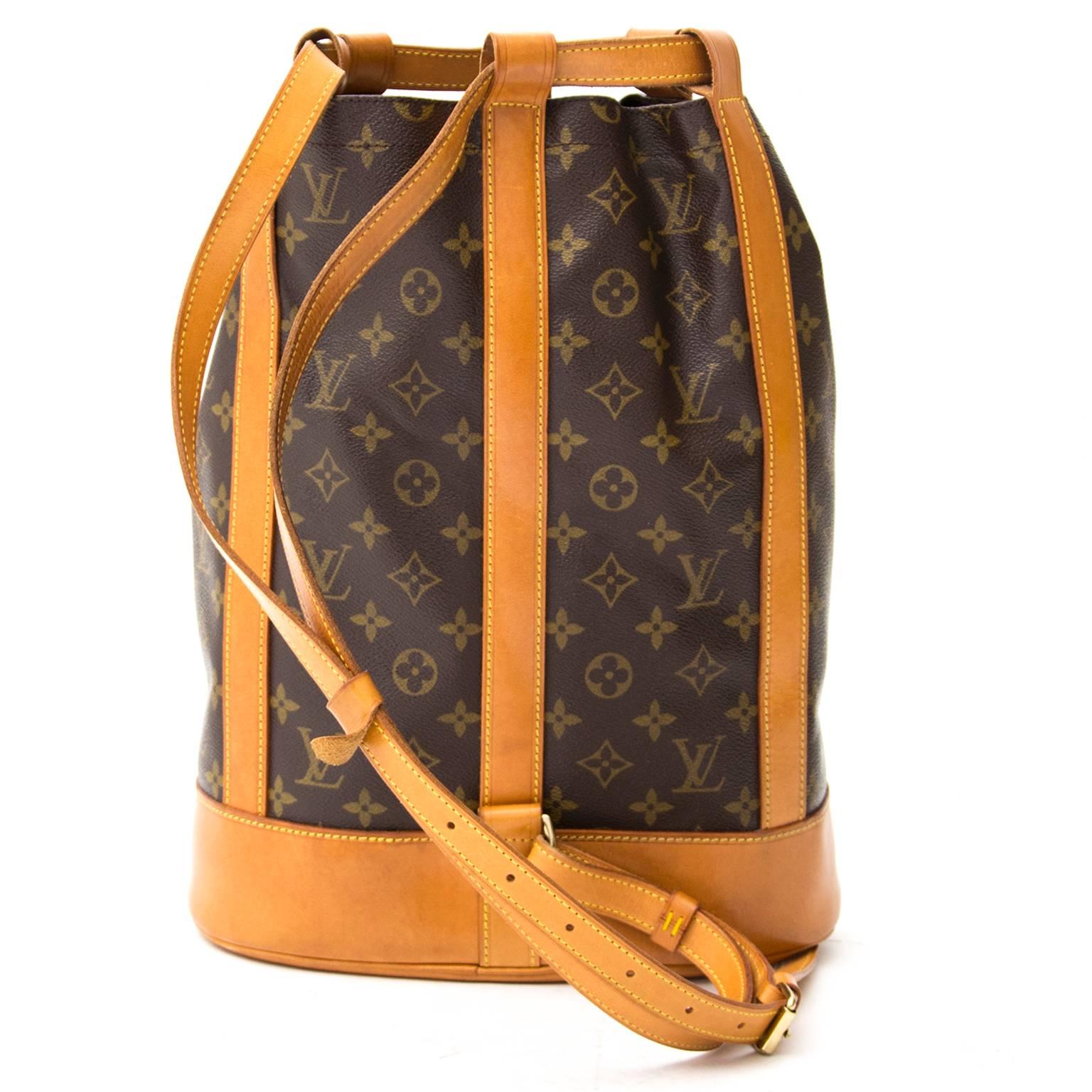 Louis Vuitton Noé in signature monogram with leather strap closure and gold-tone metallic hardware. Interior features a canvas lining and a clasp to attach your keychain. The shoulder strap with buckle is adjustable so the bag is easy to wear.  
